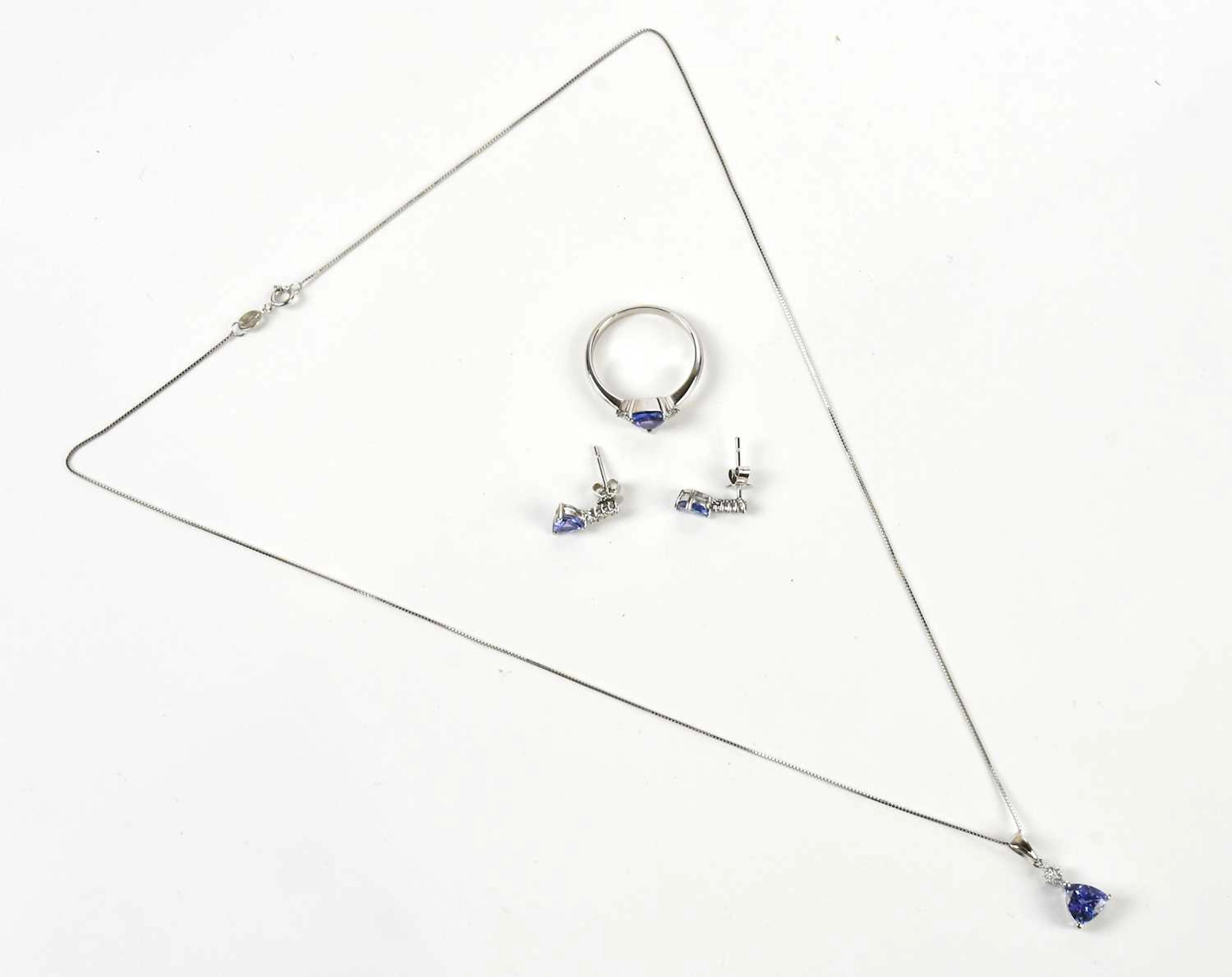 A white metal diamond and tanzanite pendant stamped 14K...