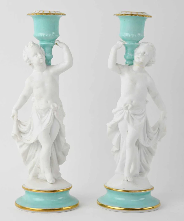 A pair of early 20th century French bisque porcelain figural candlesticks