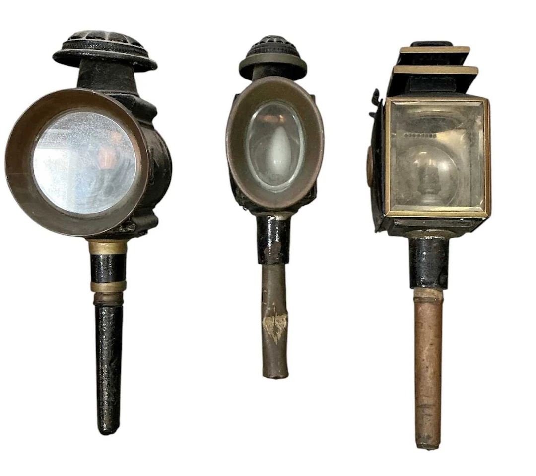 Three assorted early 20th century black painted carriage type lanterns