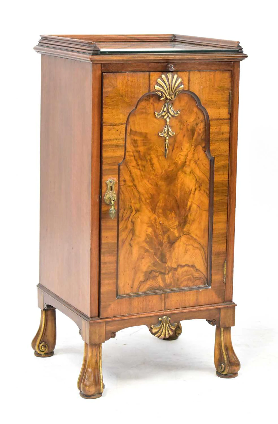 A 1930s walnut bedside cupboard with carved shell motifs
