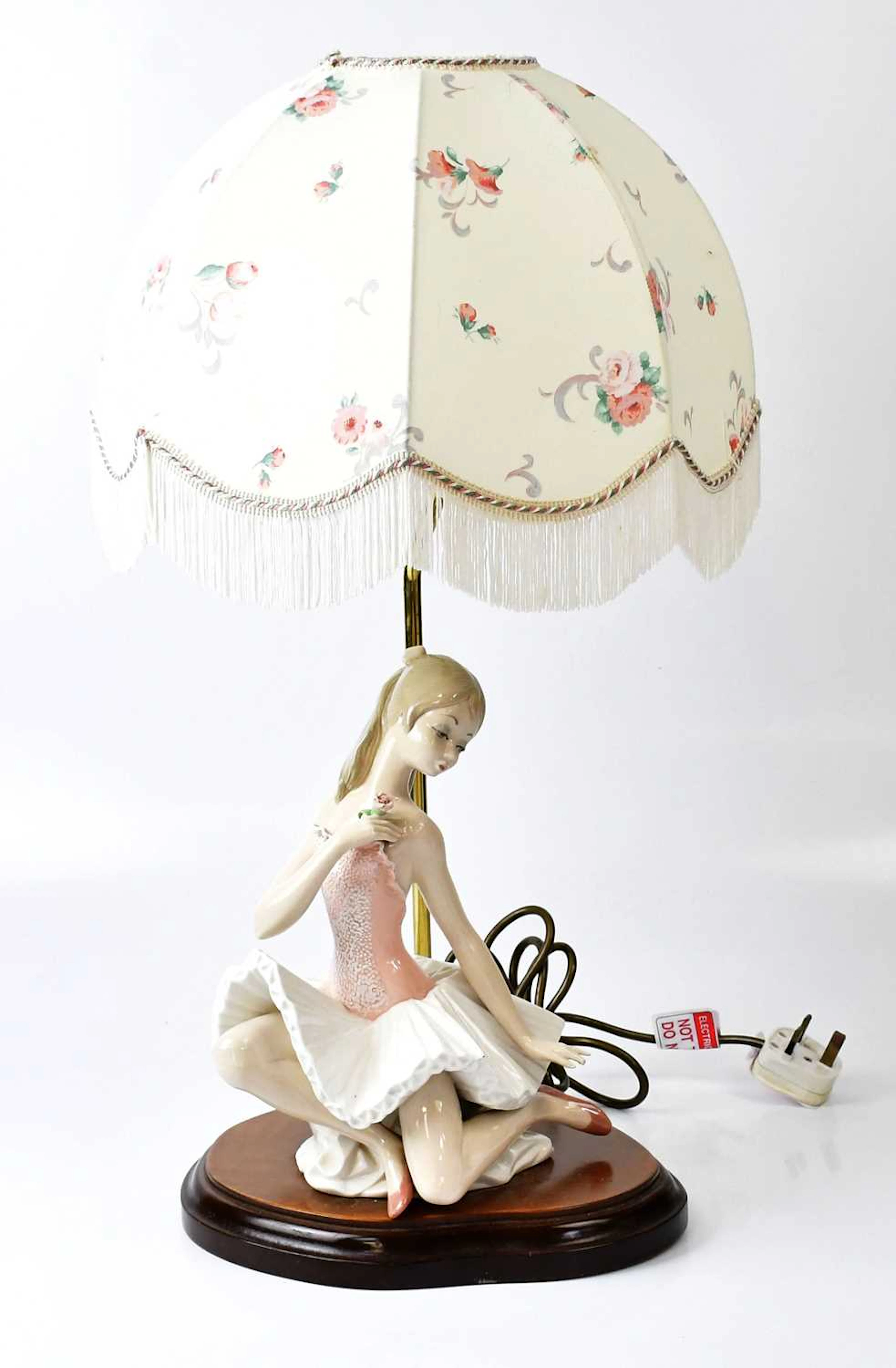 A table lamp with a Lladro style figure of a young...