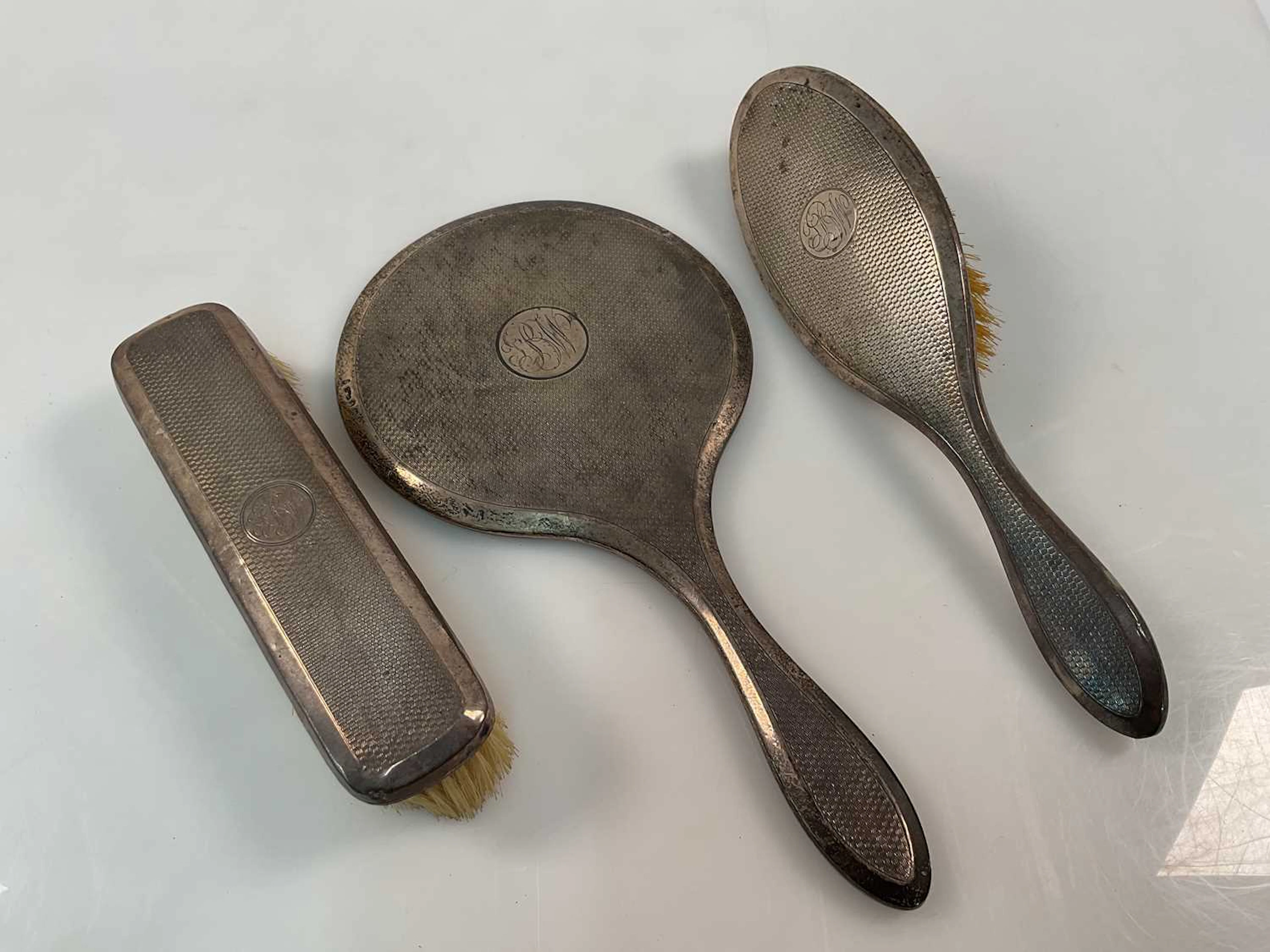 A George V hallmarked silver three piece dressing table set