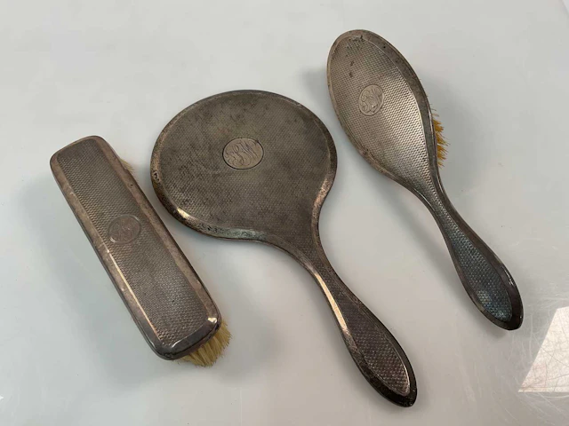 A George V hallmarked silver three piece dressing table set