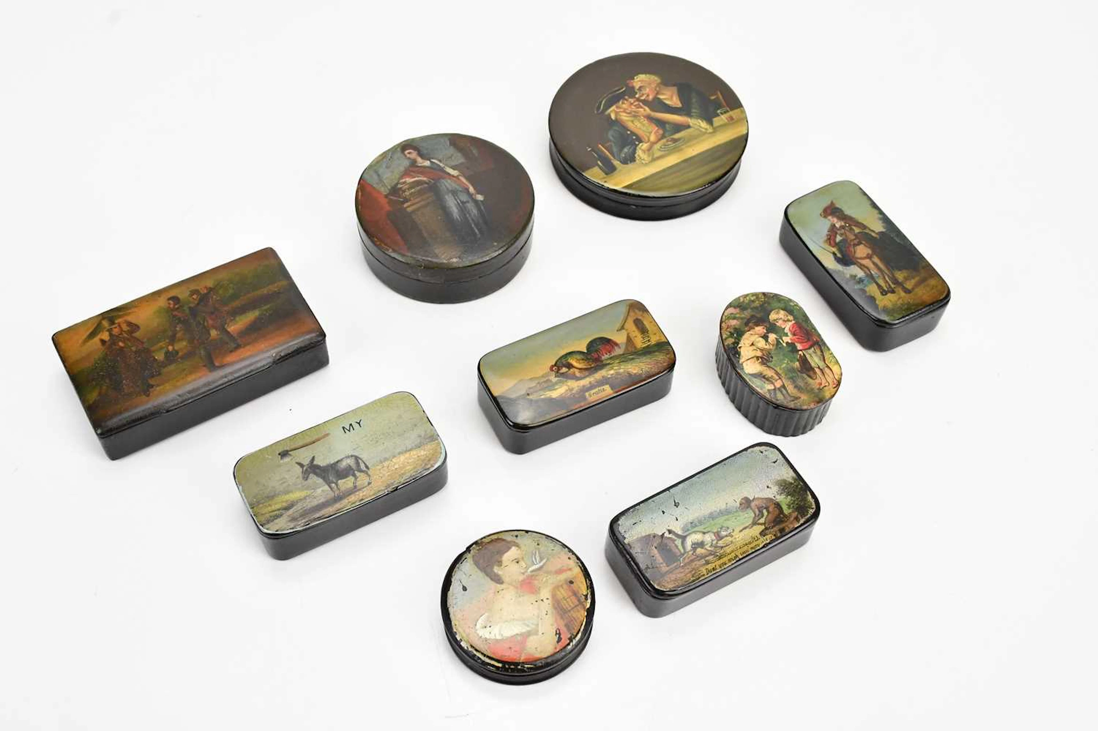 Nine Victorian hand painted and transfer printed papier-mâché snuff boxes