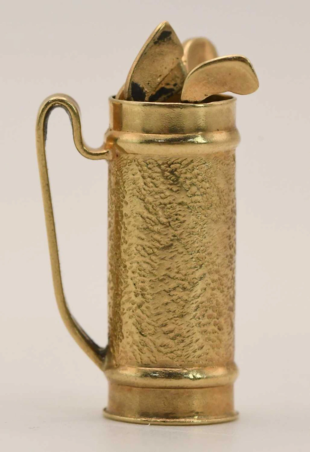 A 9ct yellow gold golf bag pendant with three golf clubs