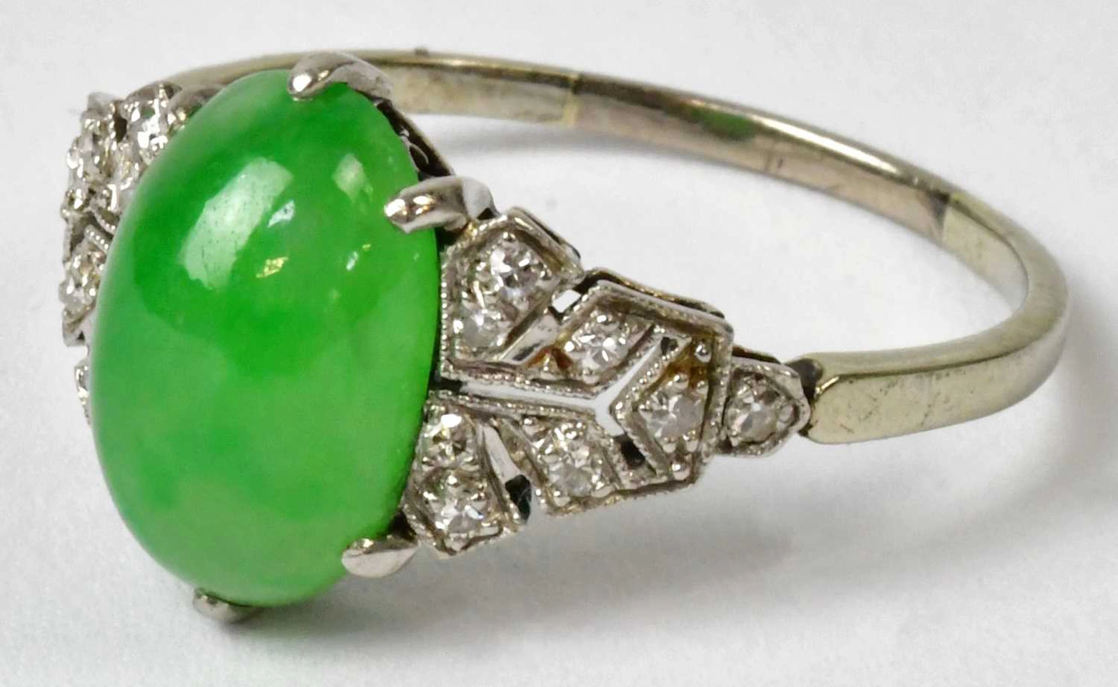 A white metal Art Deco ring set with a central green jade oval cabochon