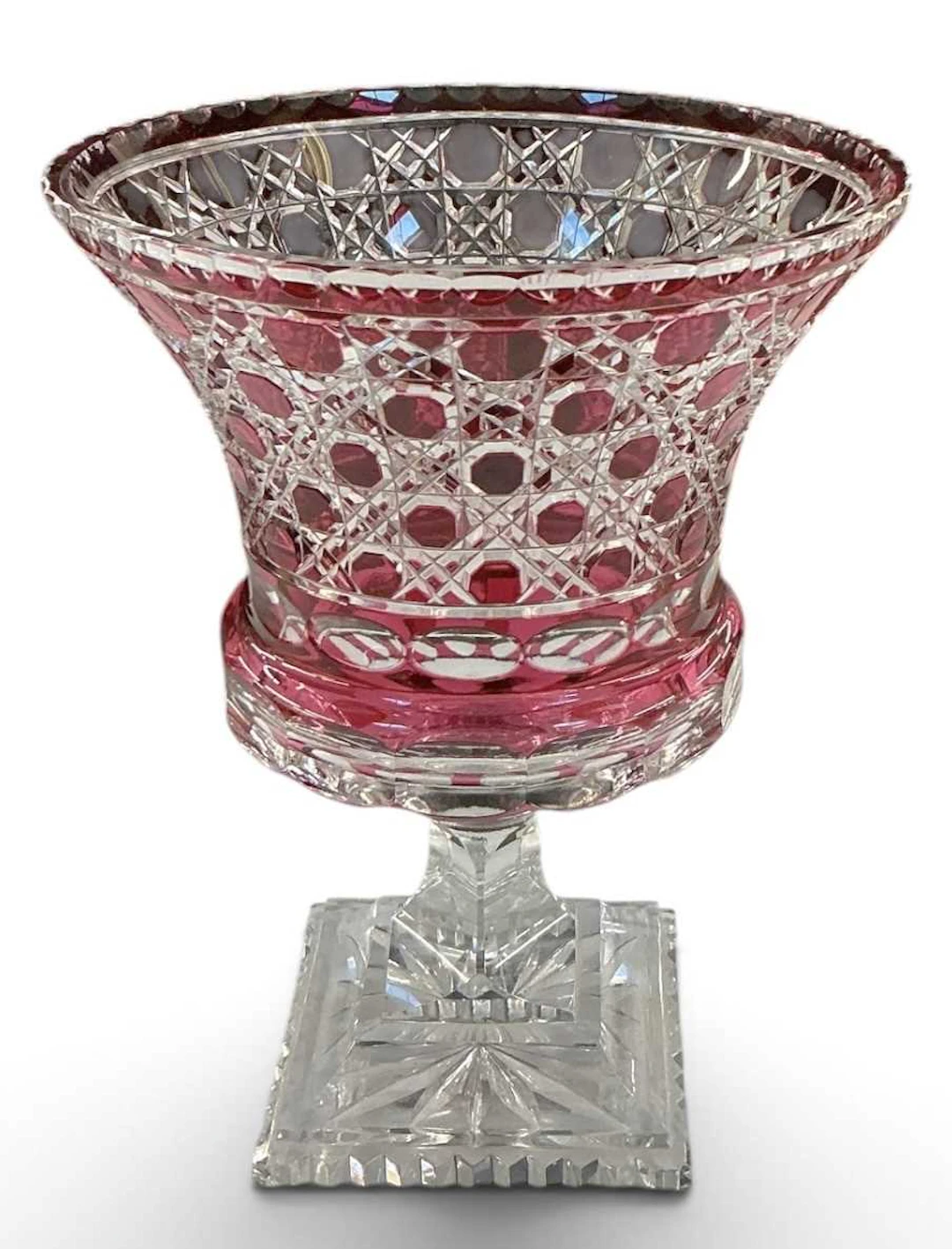 A Bohemian cranberry cut glass urn form footed vase