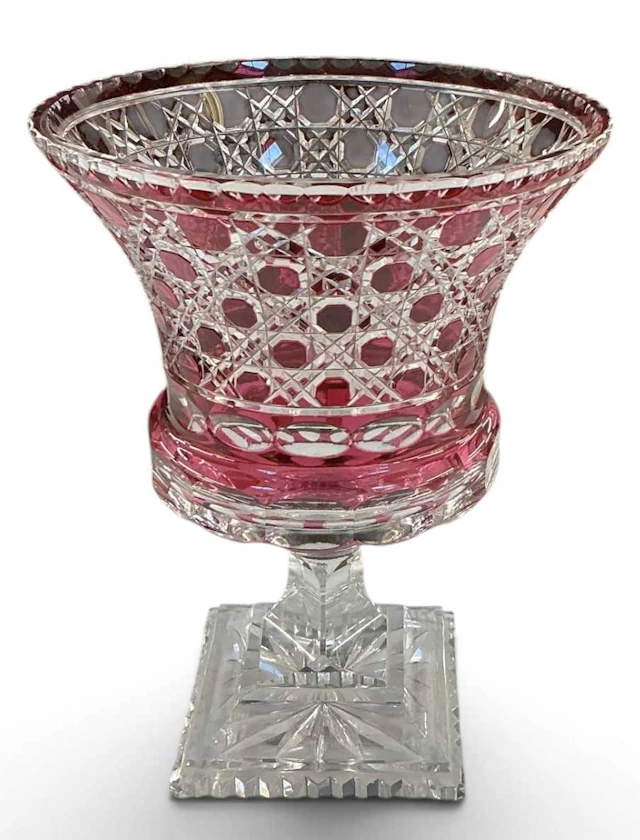 A Bohemian cranberry cut glass urn form footed vase