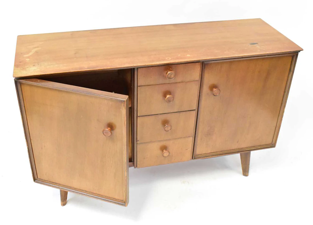 A mid-20th century teak sideboard comprising four central...