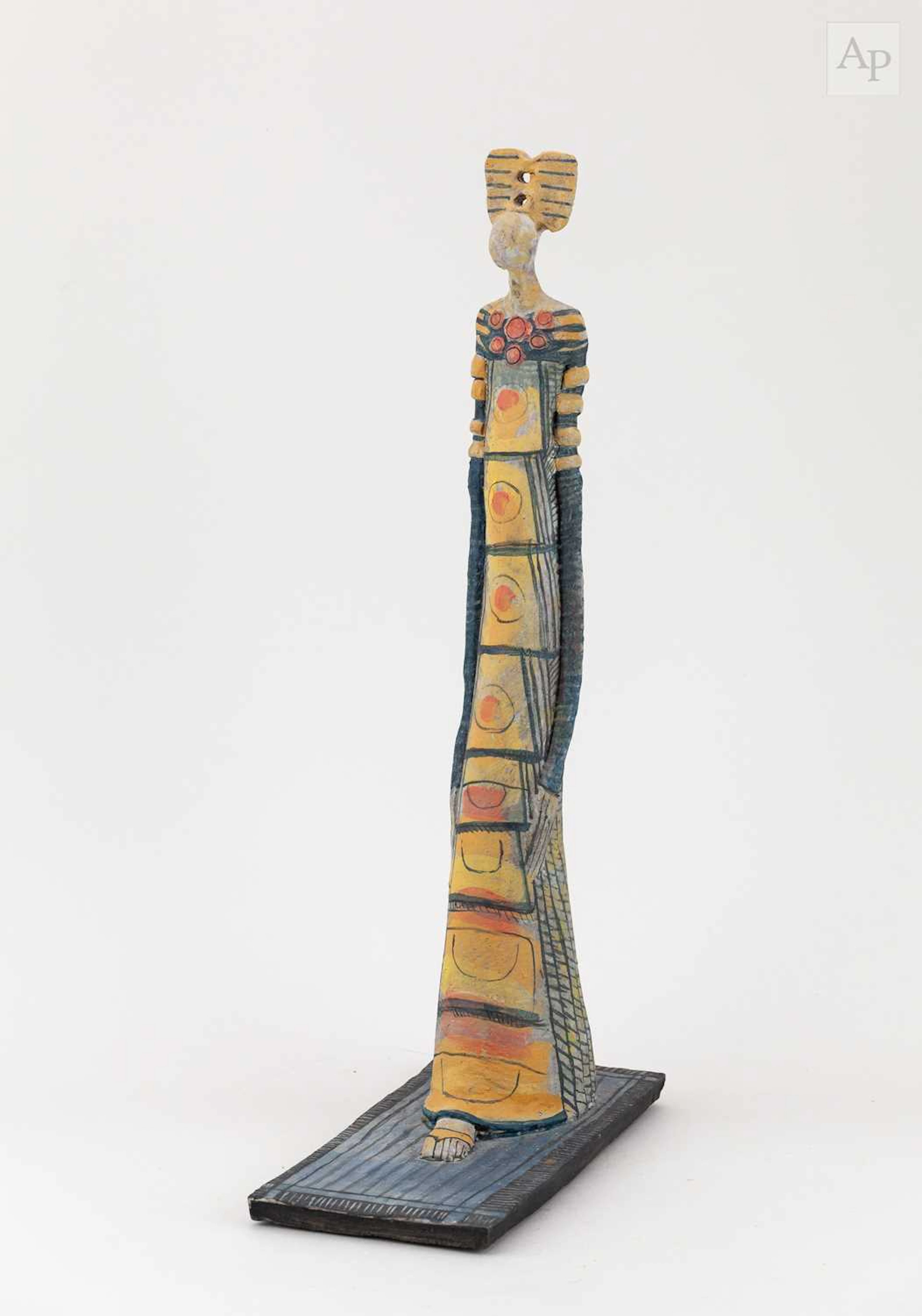 A tall earthenware sculpture of a standing female with...