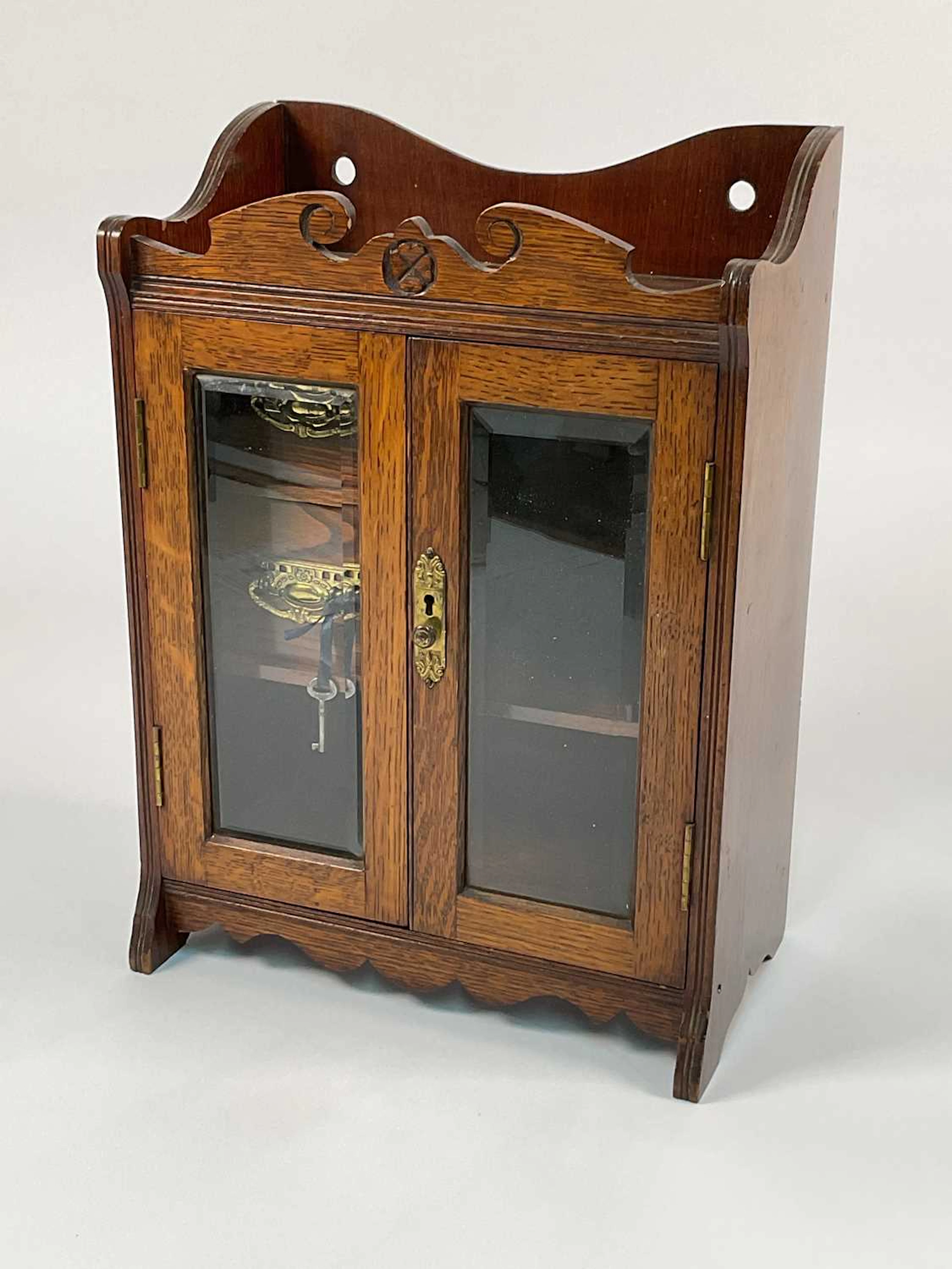 A 19th century oak smoker's cabinet with bevelled glazed doors