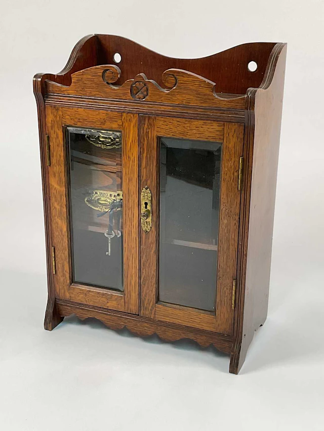 A 19th century oak smoker's cabinet with bevelled glazed doors