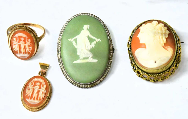A 9ct yellow gold ring set with an oval cameo depicting three Classical ladies