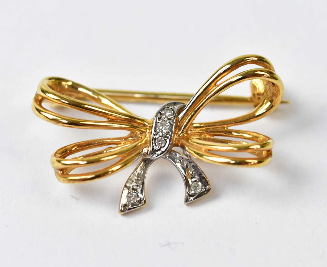 A 9ct yellow and white gold brooch in the form of a bow