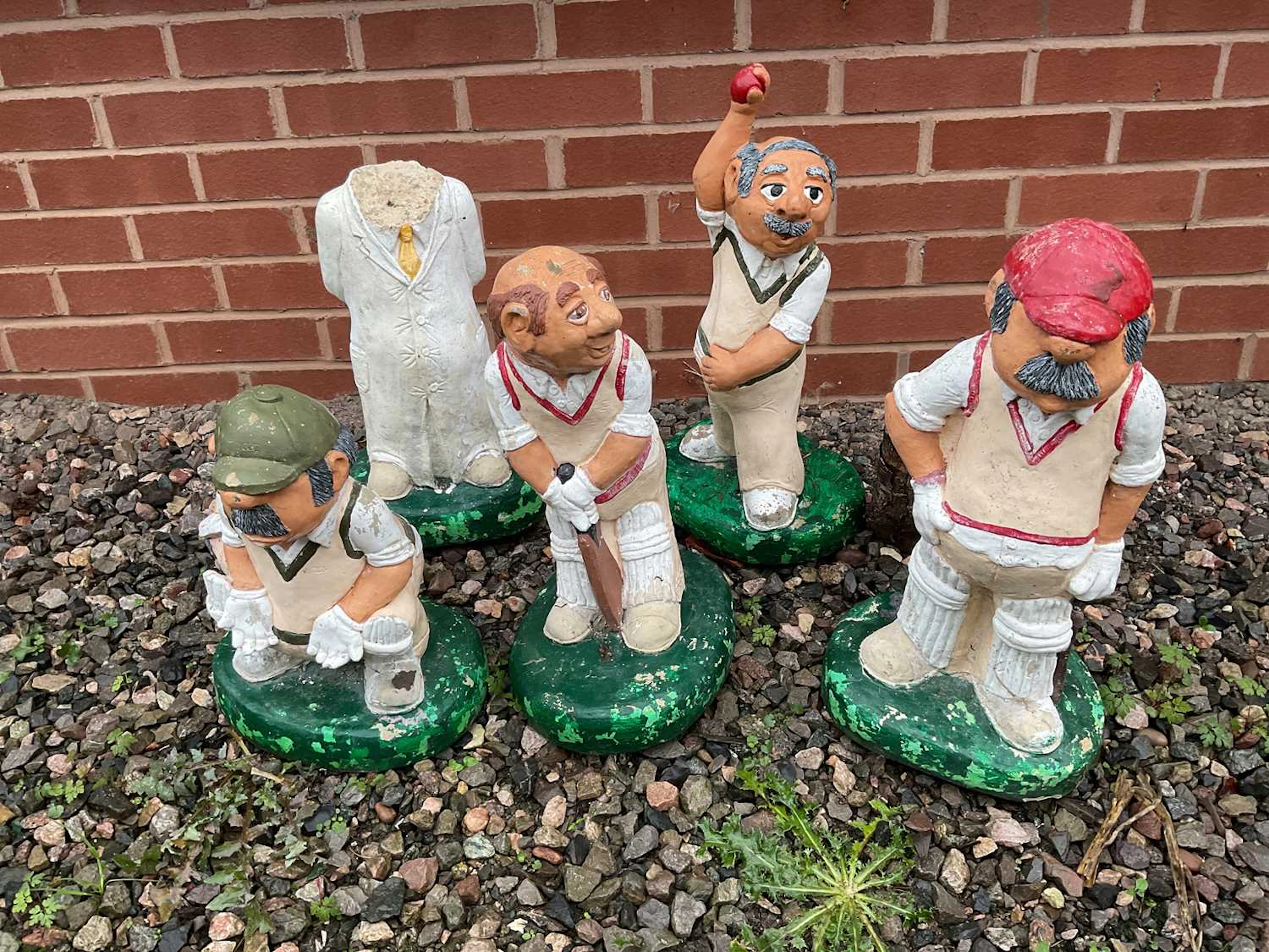 Five painted composite stone cricketing garden ornaments