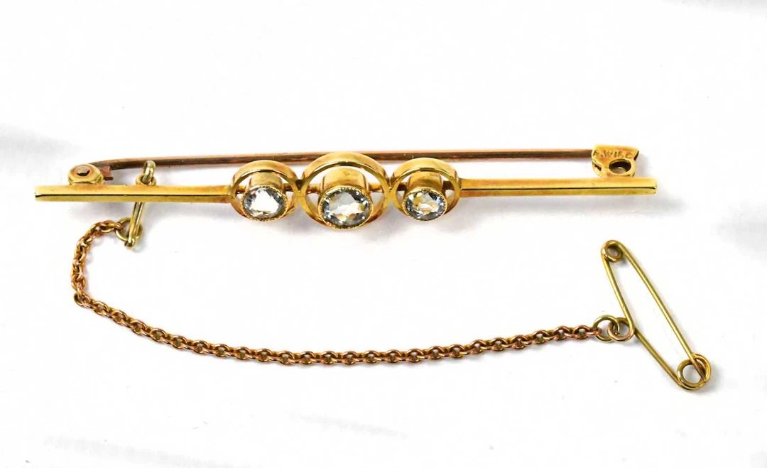 A 15ct yellow gold bar brooch set with three aquamarines