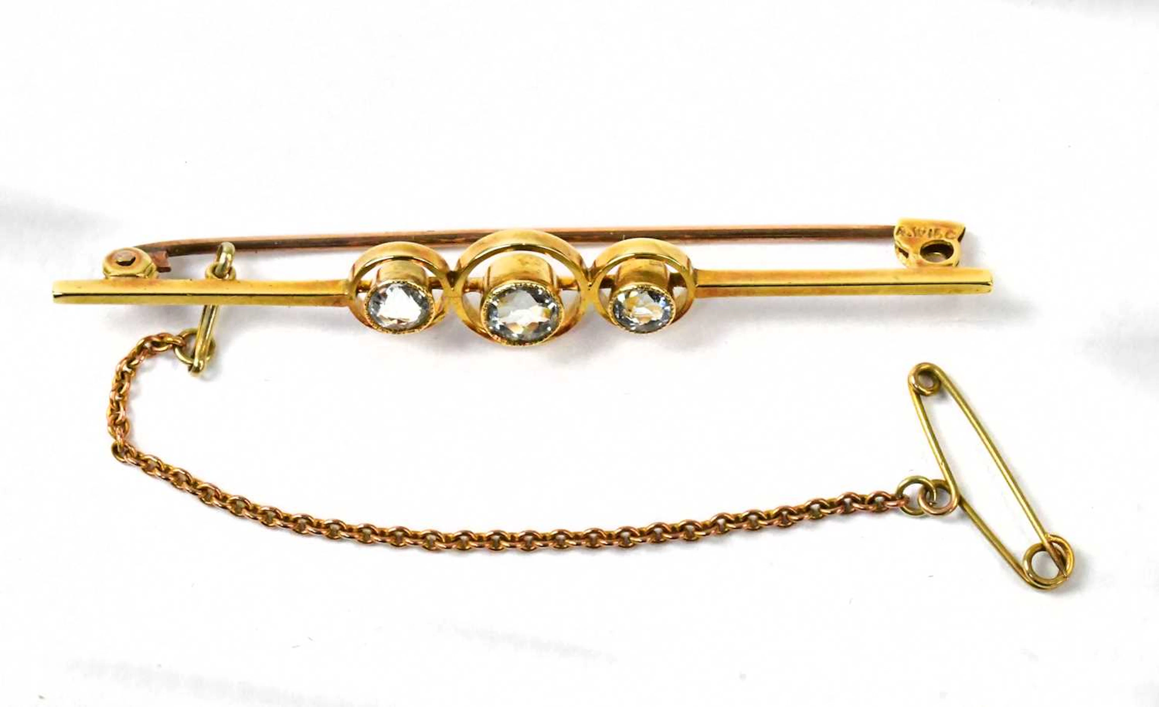 A 15ct yellow gold bar brooch set with three aquamarines