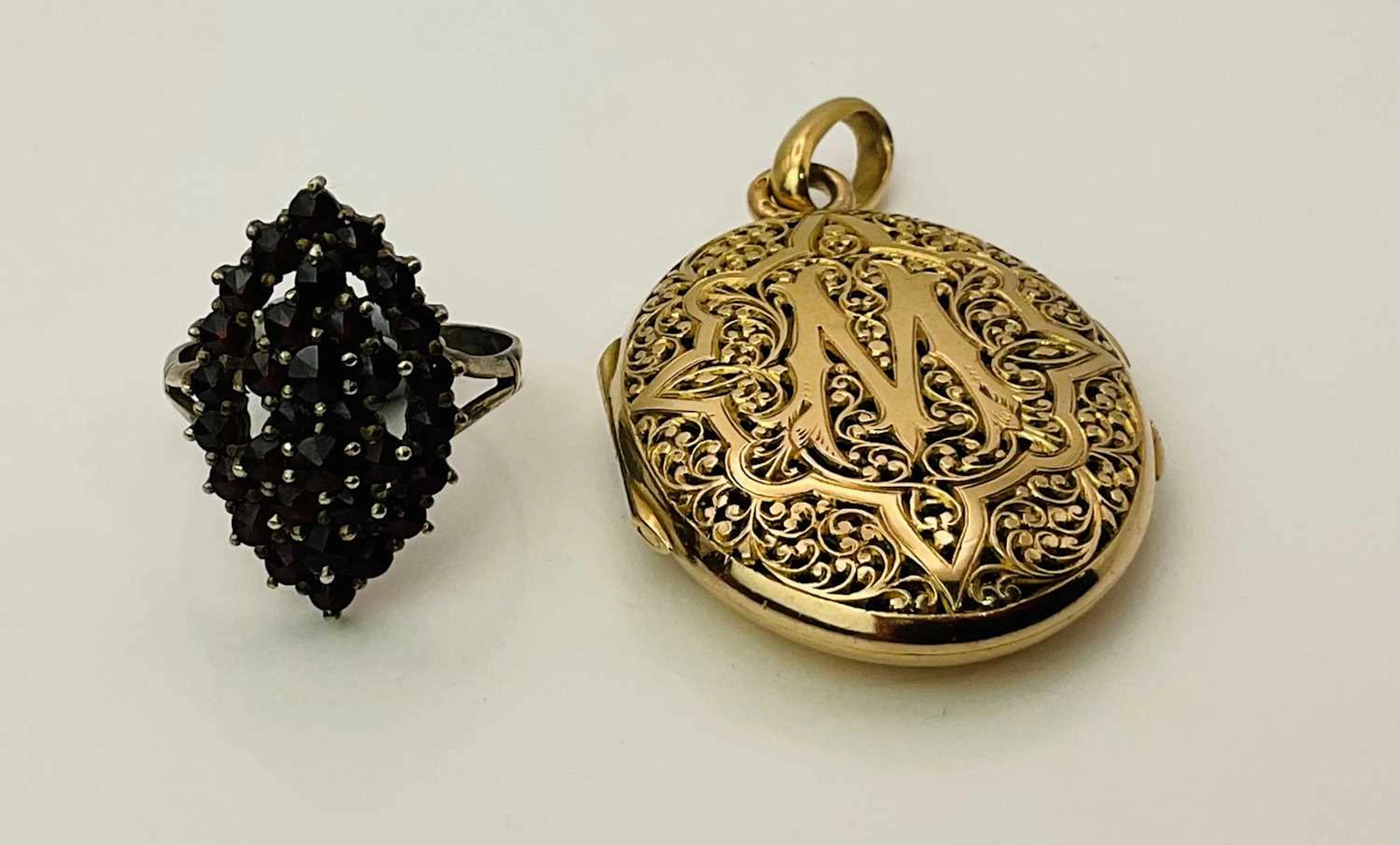 A yellow metal oval locket pendant with pierced front