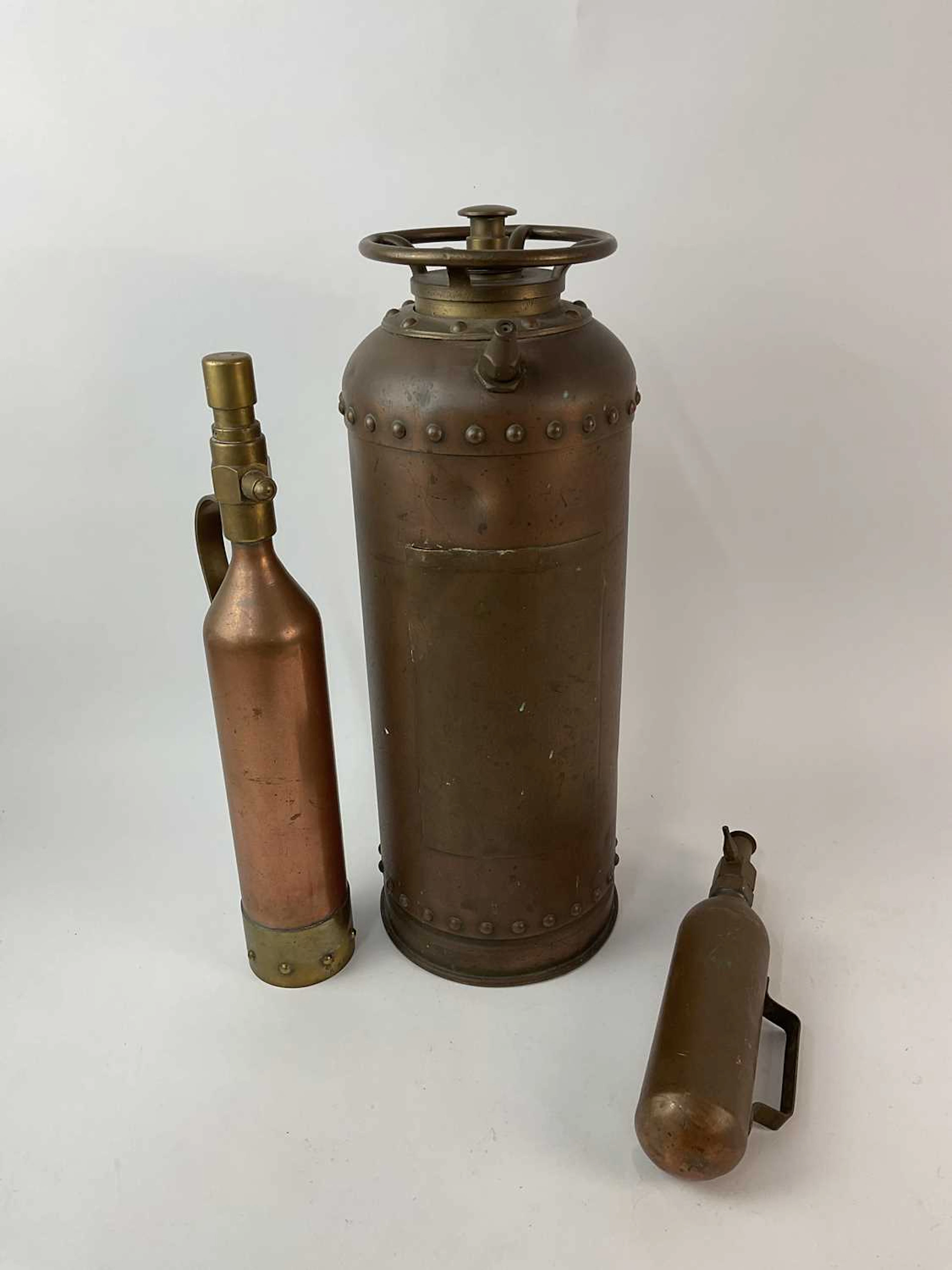 Three copper and brass fire extinguishers
