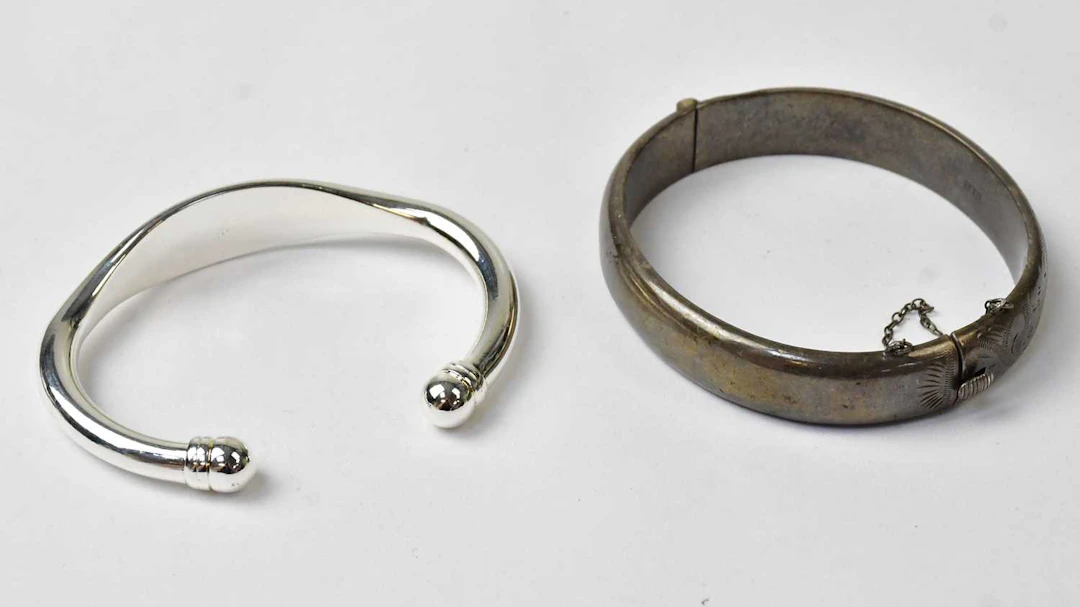 A hallmarked silver hinged bangle with safety chain