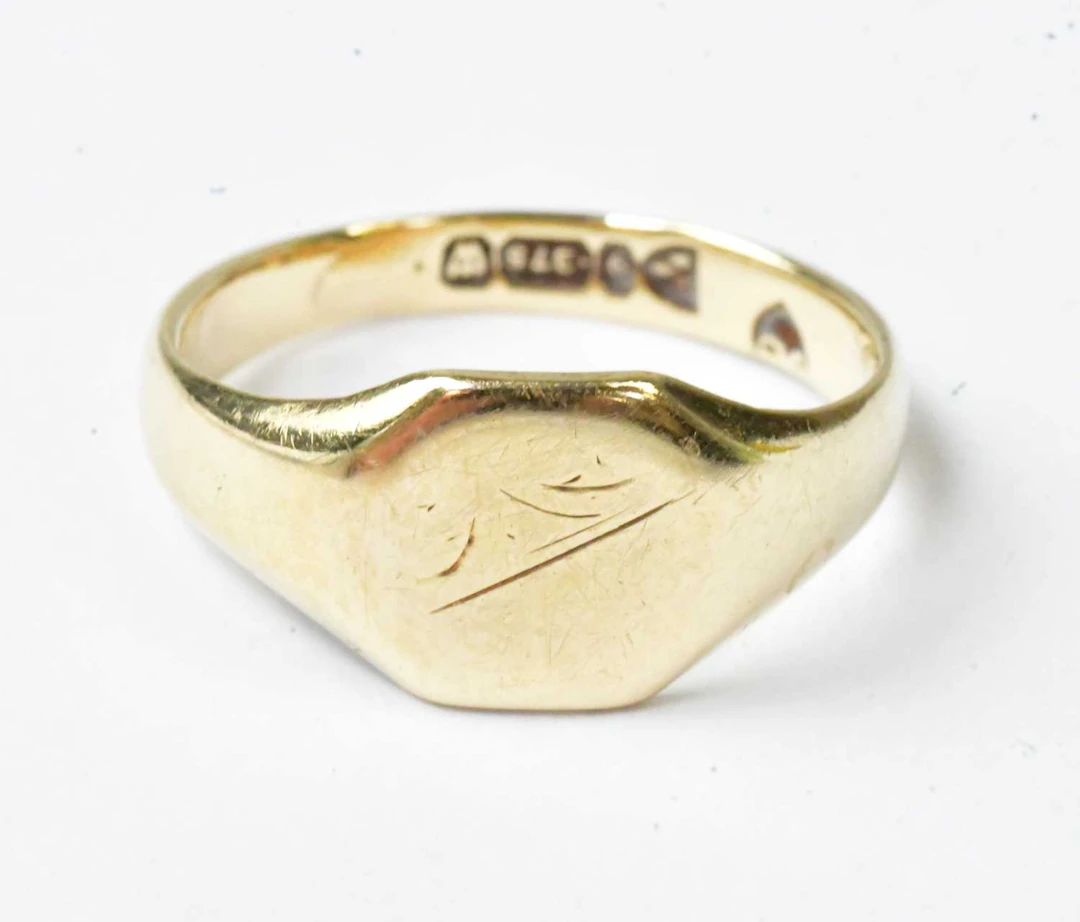 A 9ct yellow gold signet ring with engraving to the octagonal bezel (rubbed)