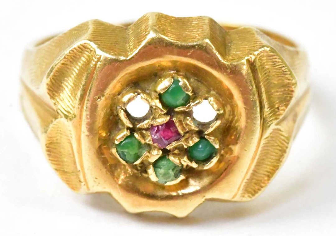 An 18ct yellow gold ring set with red and green stones (lacking two stones)