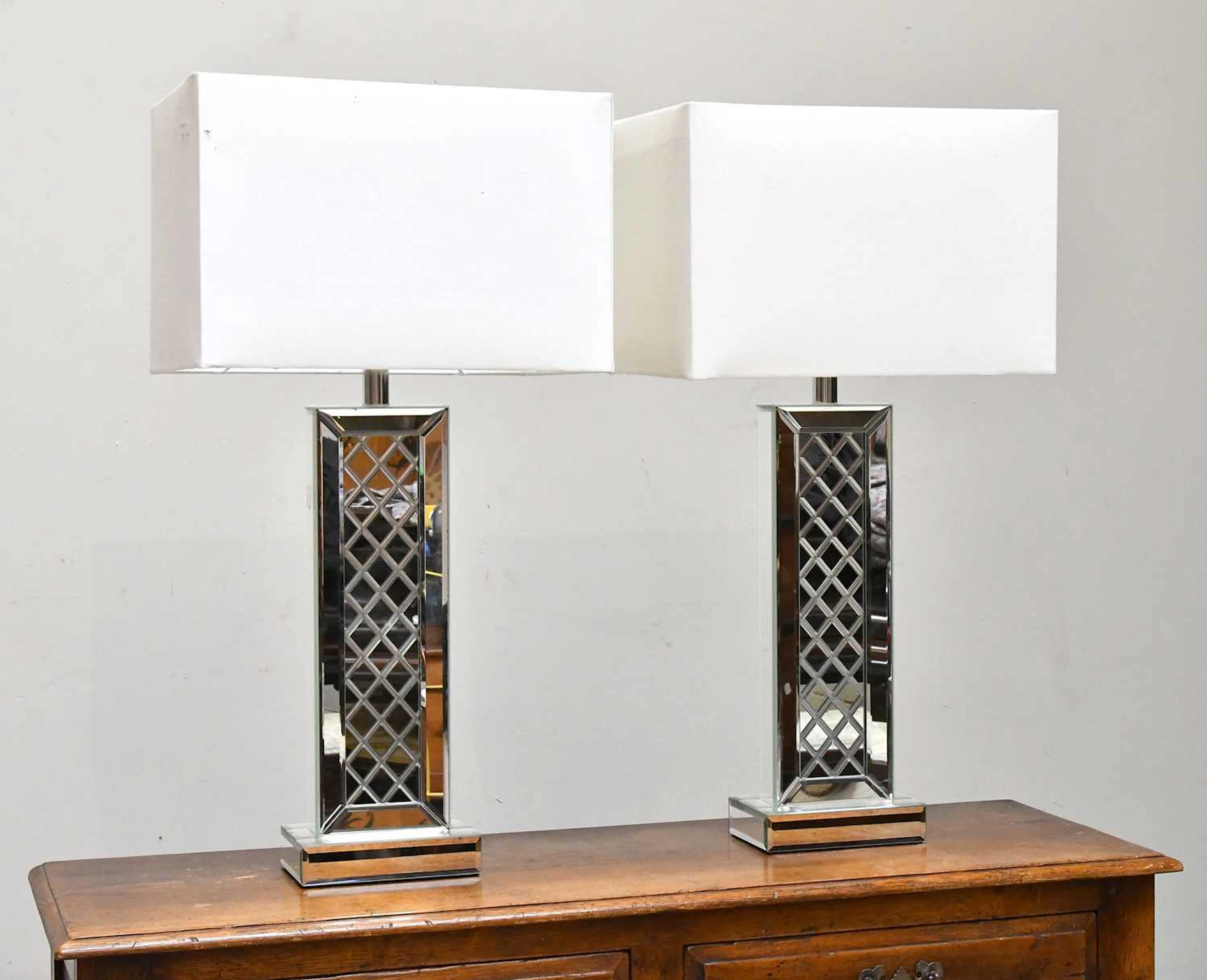 A pair of modern mirrored glass table lamps of rectangular form
