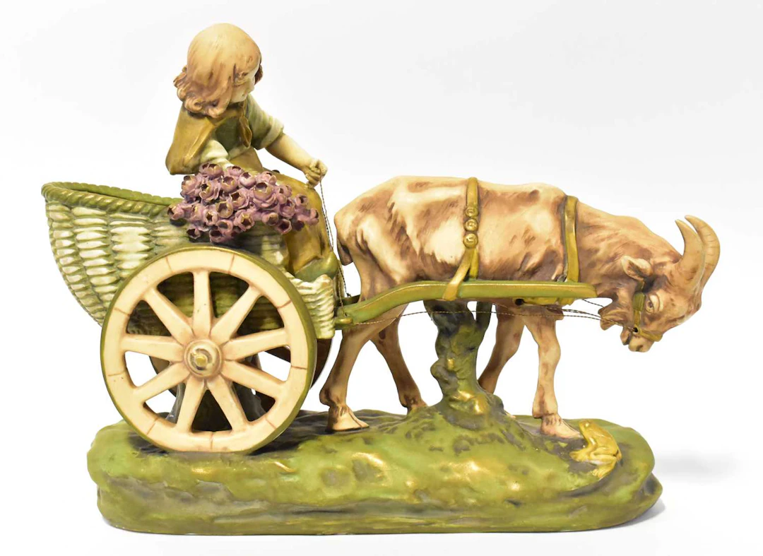 A Royal Dux style porcelain figure group of a goat pulling a cart