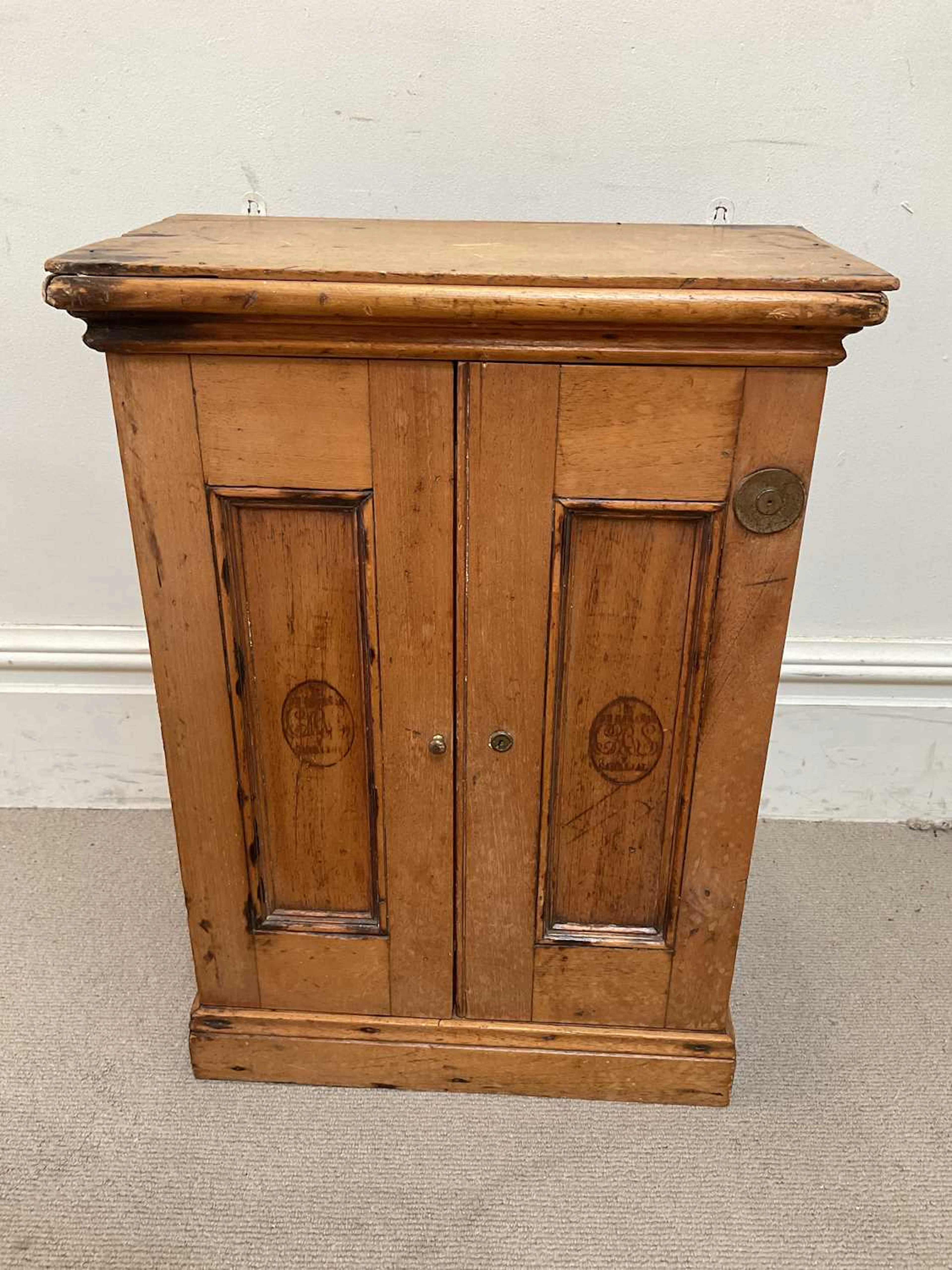 H DE CABANAS; a pine hanging cigar cabinet with two panelled doors