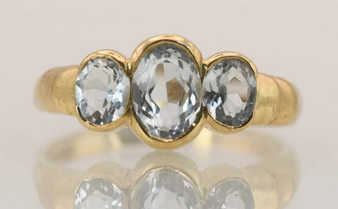 A 9ct yellow gold three topaz set ring