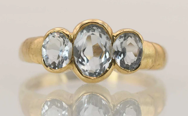A 9ct yellow gold three topaz set ring