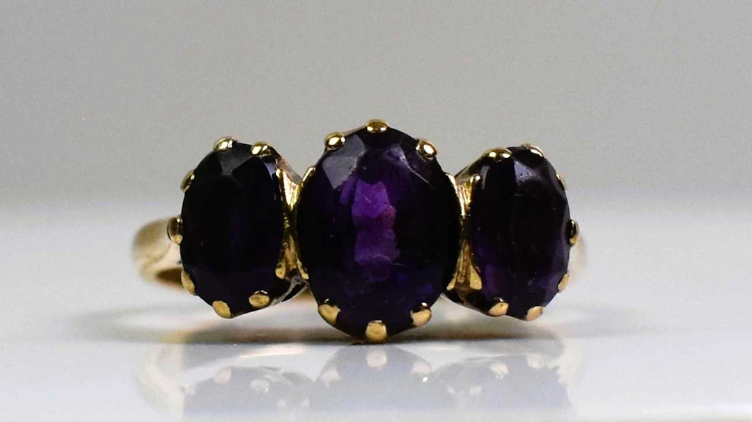 A 9ct yellow gold and three stone amethyst ring