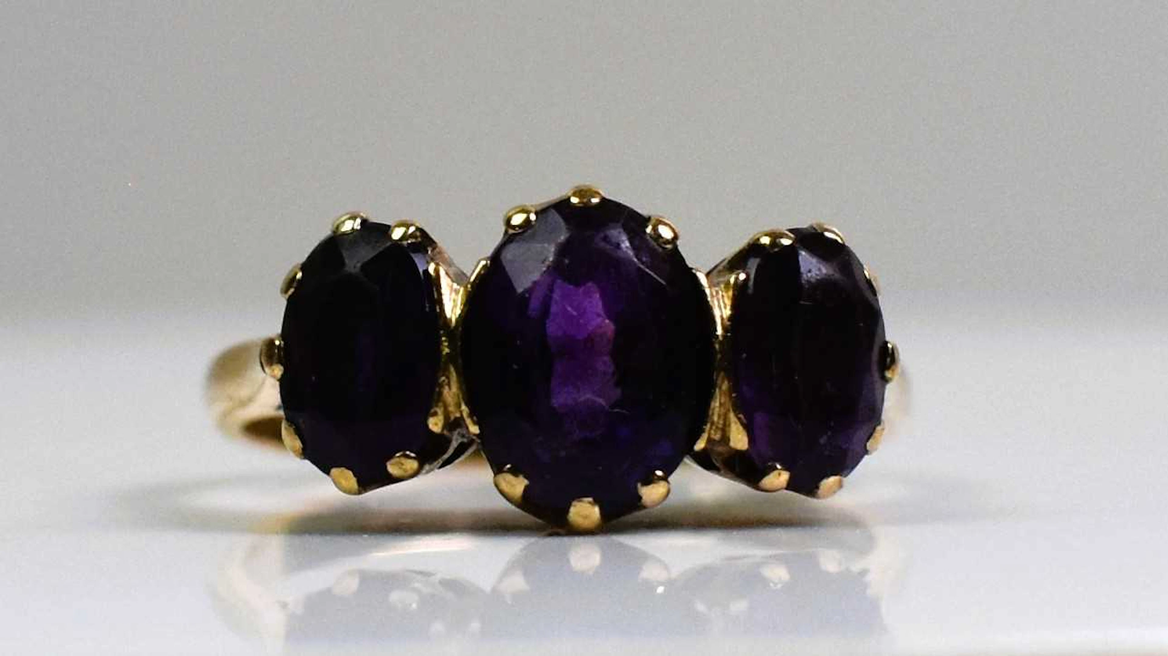 A 9ct yellow gold and three stone amethyst ring