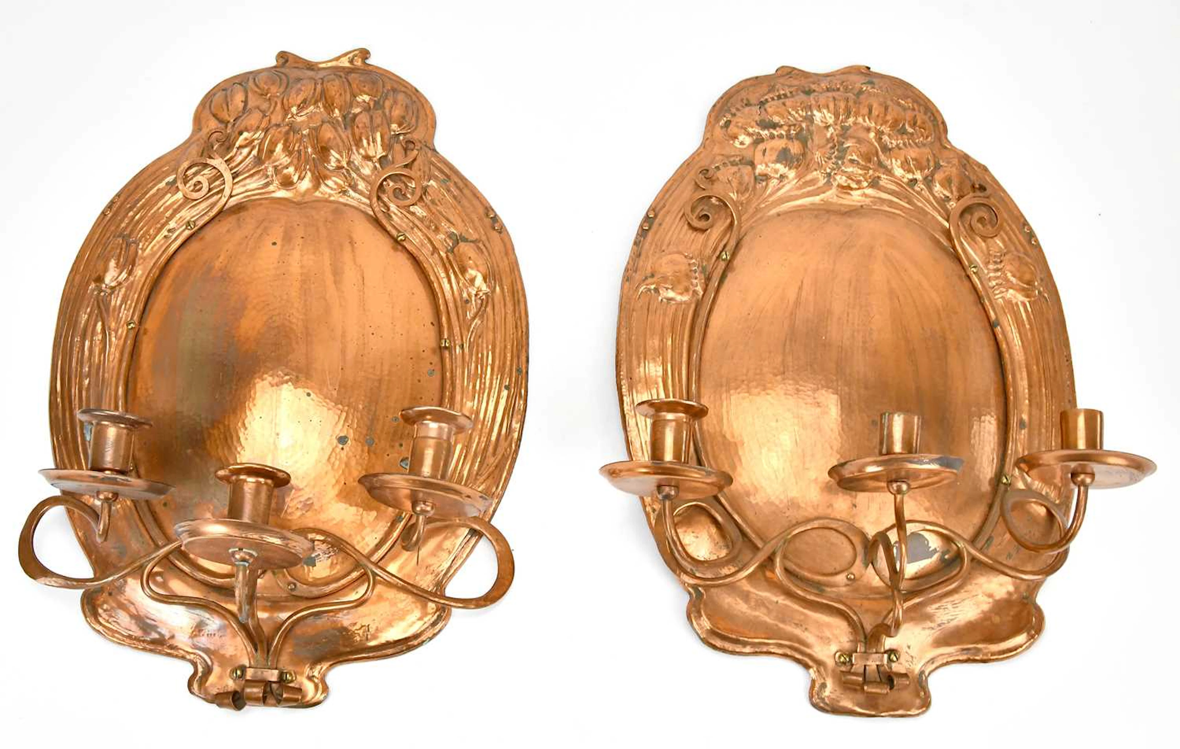 A pair of Art Nouveau copper wall sconces with embossed decoration