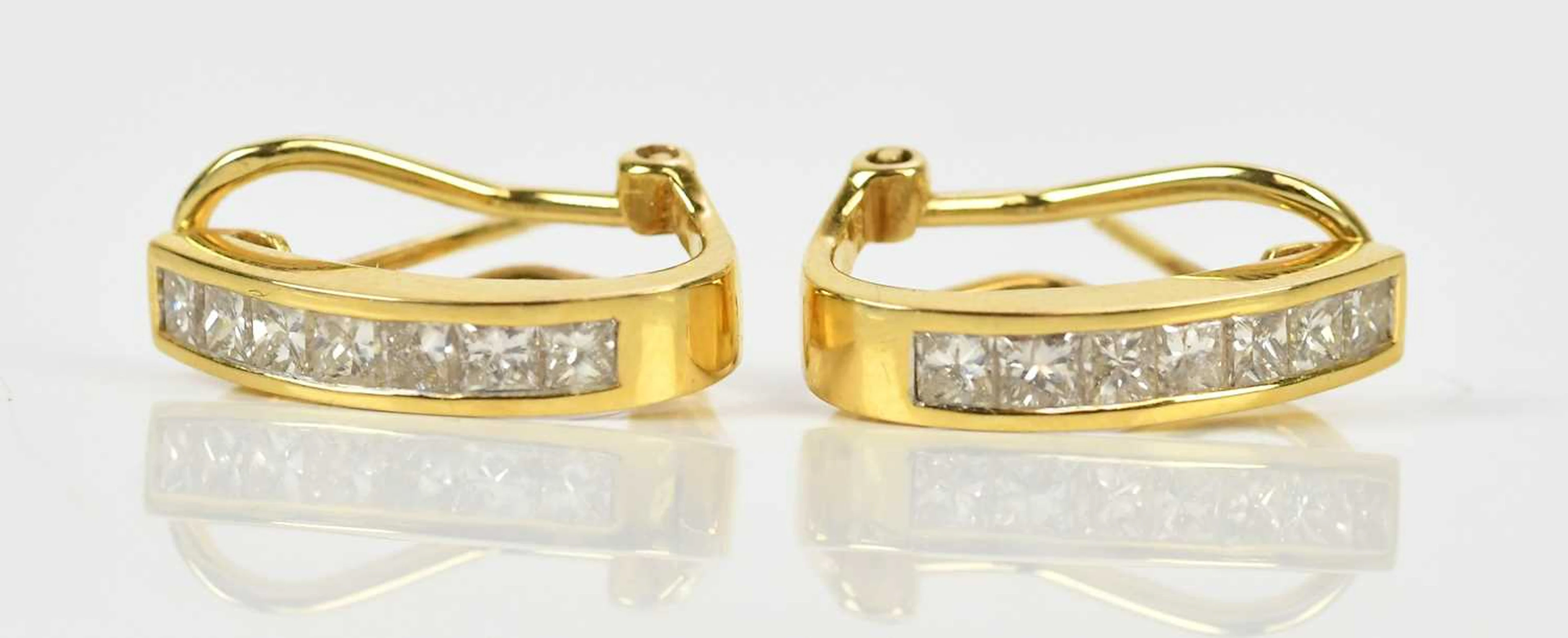 A pair of yellow metal diamond set half hoop earrings