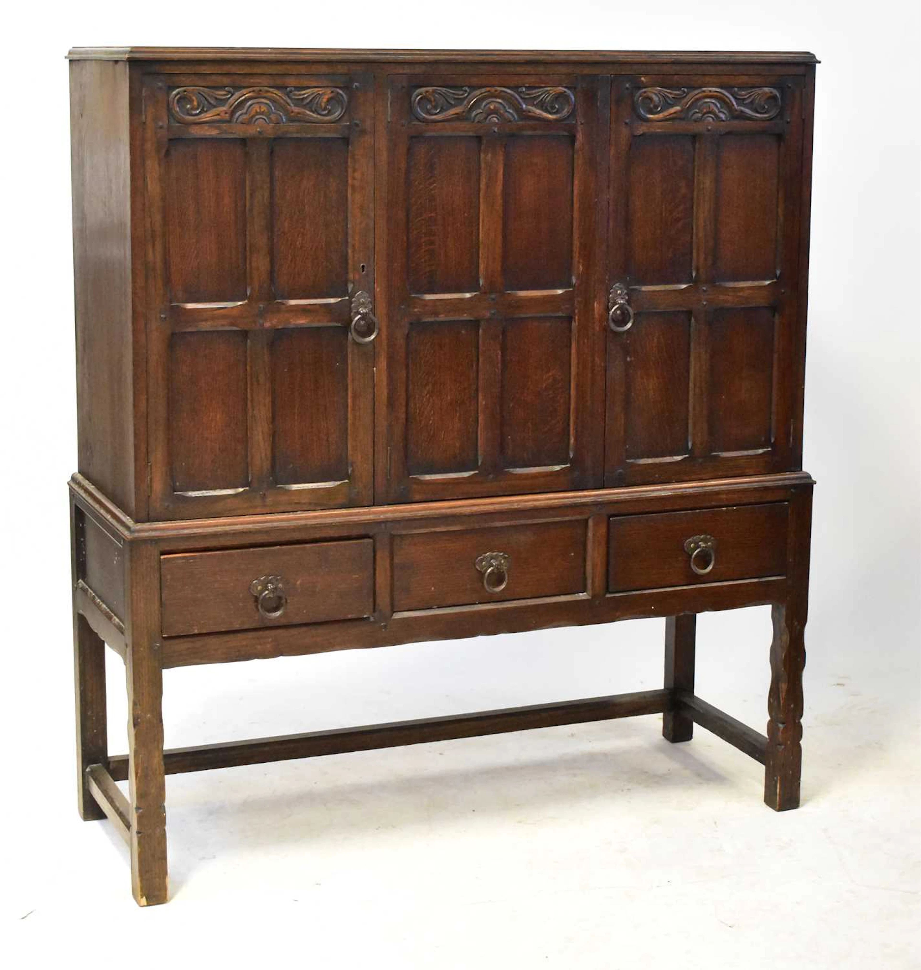 An Old Charm type carved oak cupboard