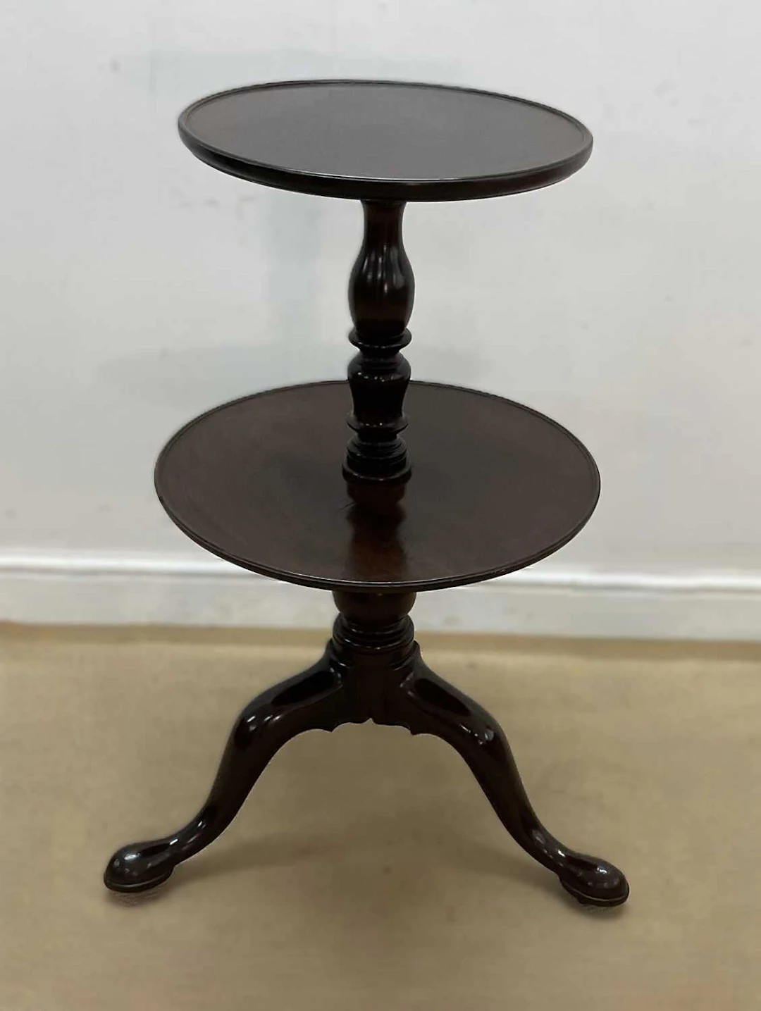 A mahogany two tier graduating dumb waiter raised on...