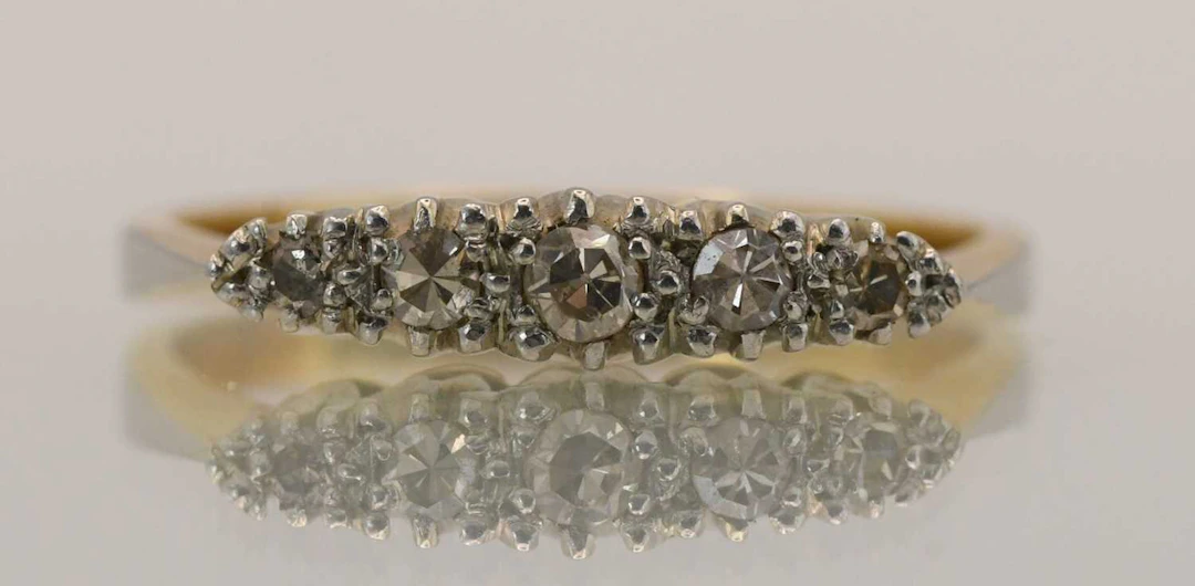 An 18ct yellow gold dress ring set with five tiny...