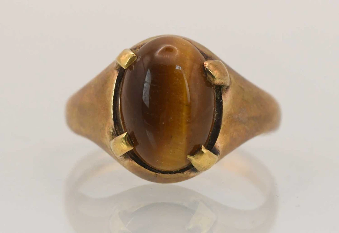 A 9ct rose gold signet ring with four claw set tiger's eye stone