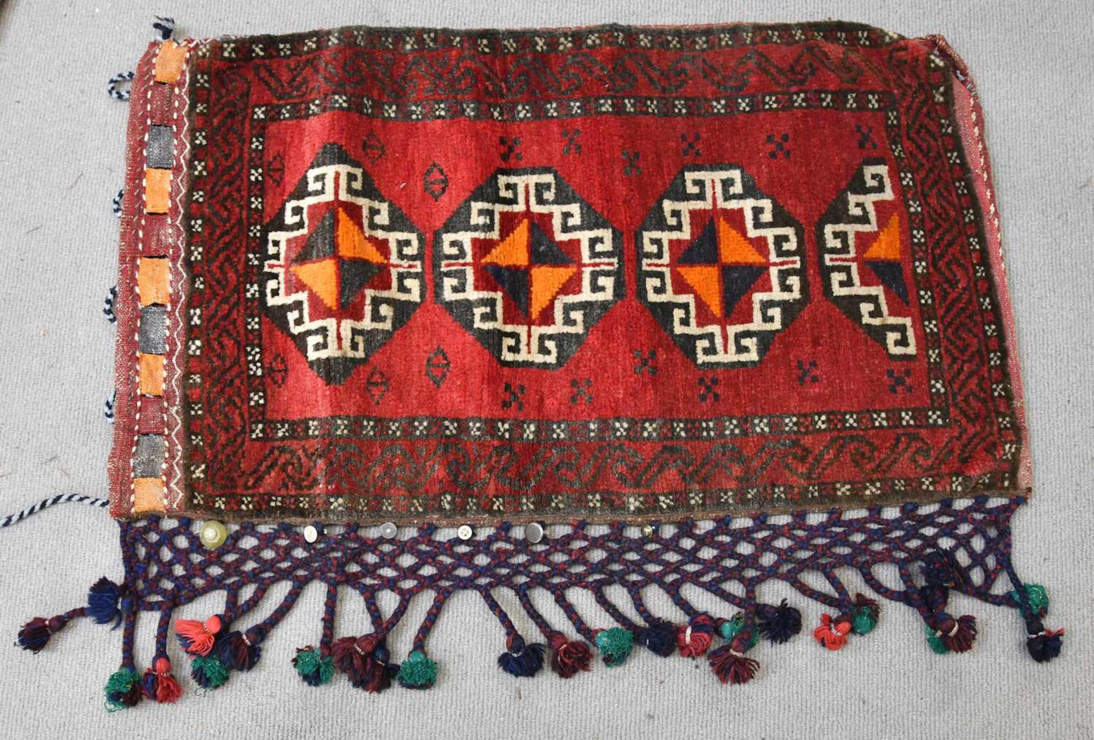 An Eastern saddle bag with stylised detail on a red ground