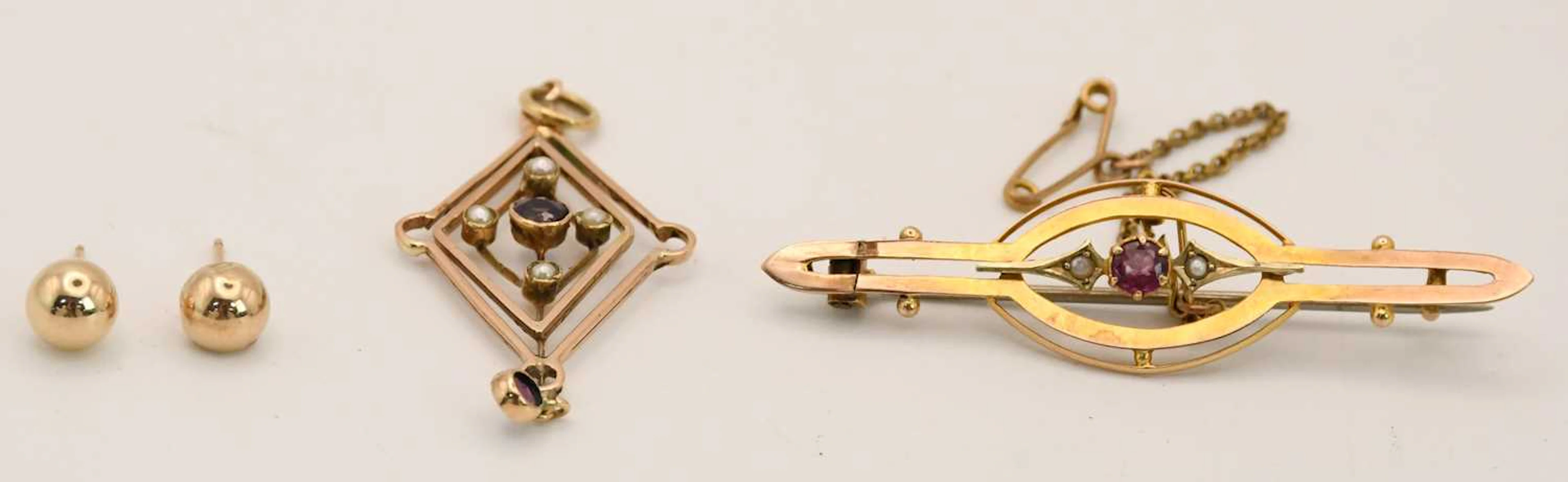 An unmarked yellow metal Victorian bar brooch set with tiny ruby and seed pearls