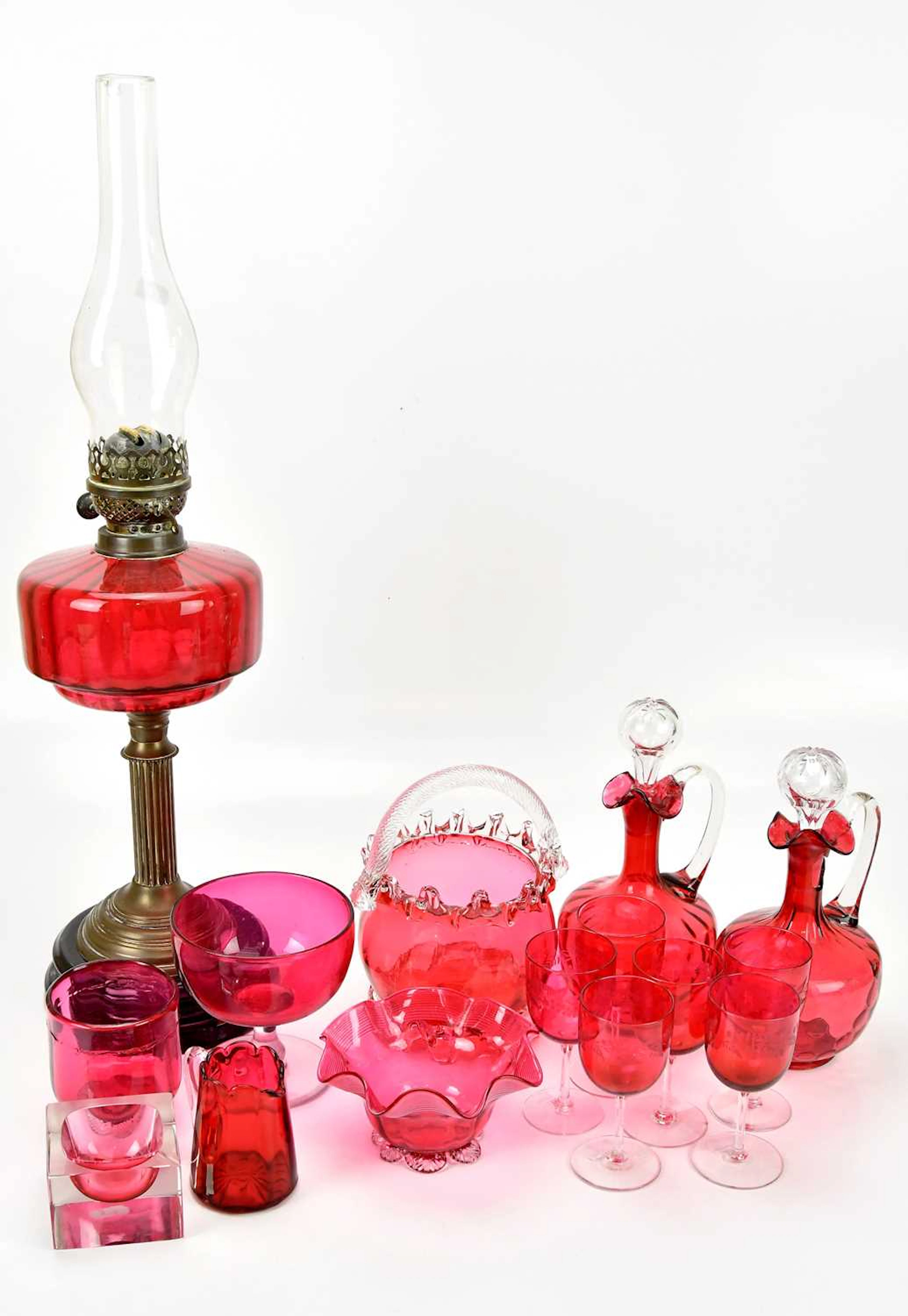 A collection of Victorian cranberry glassware including oil lamp
