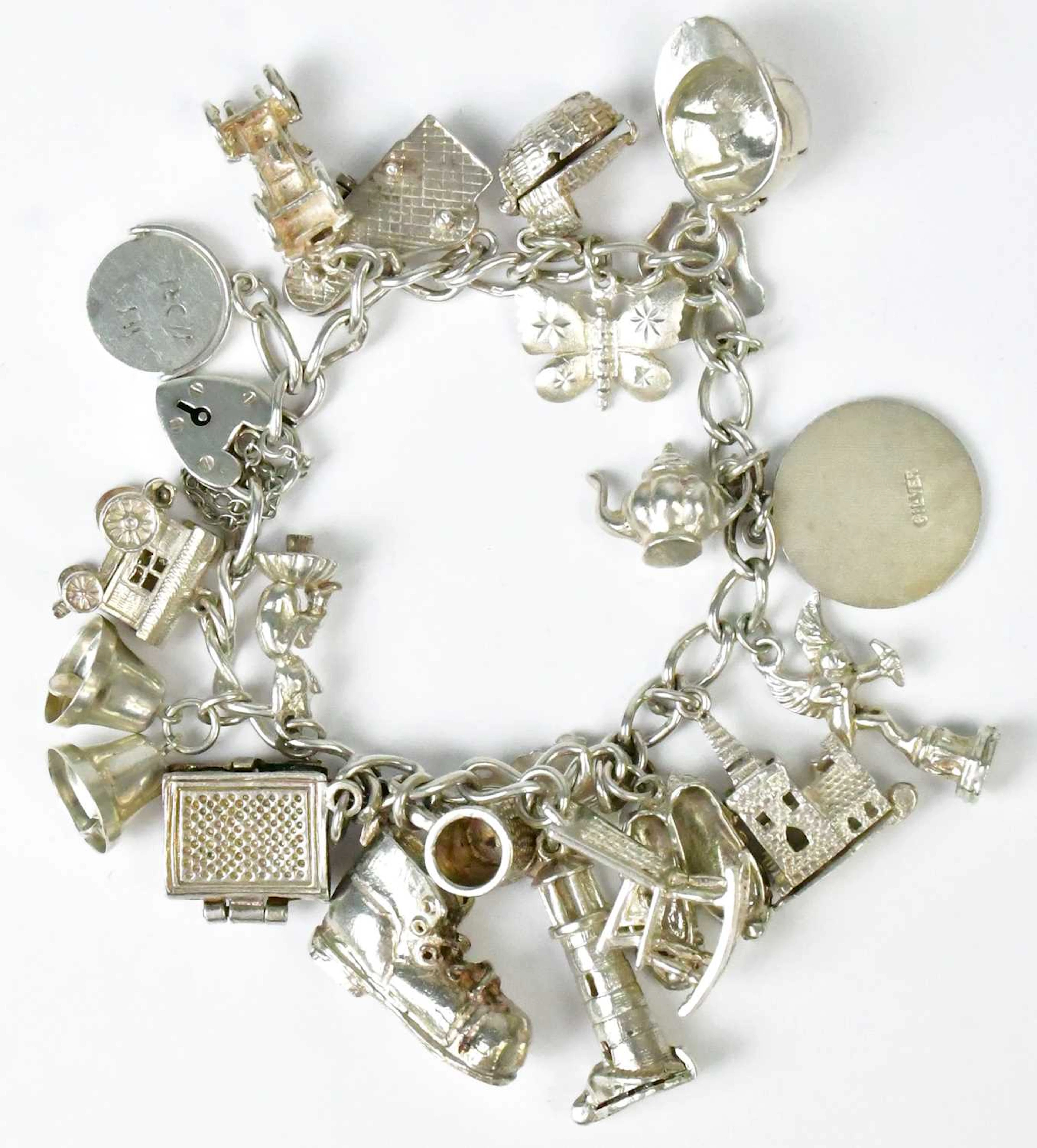 A hallmarked silver charm bracelet with a heart-shaped...