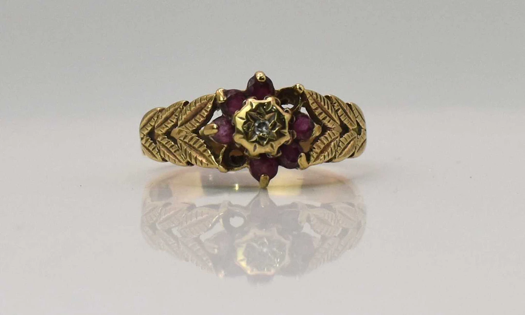 A yellw metal diamon and garnet set flower head cluster...