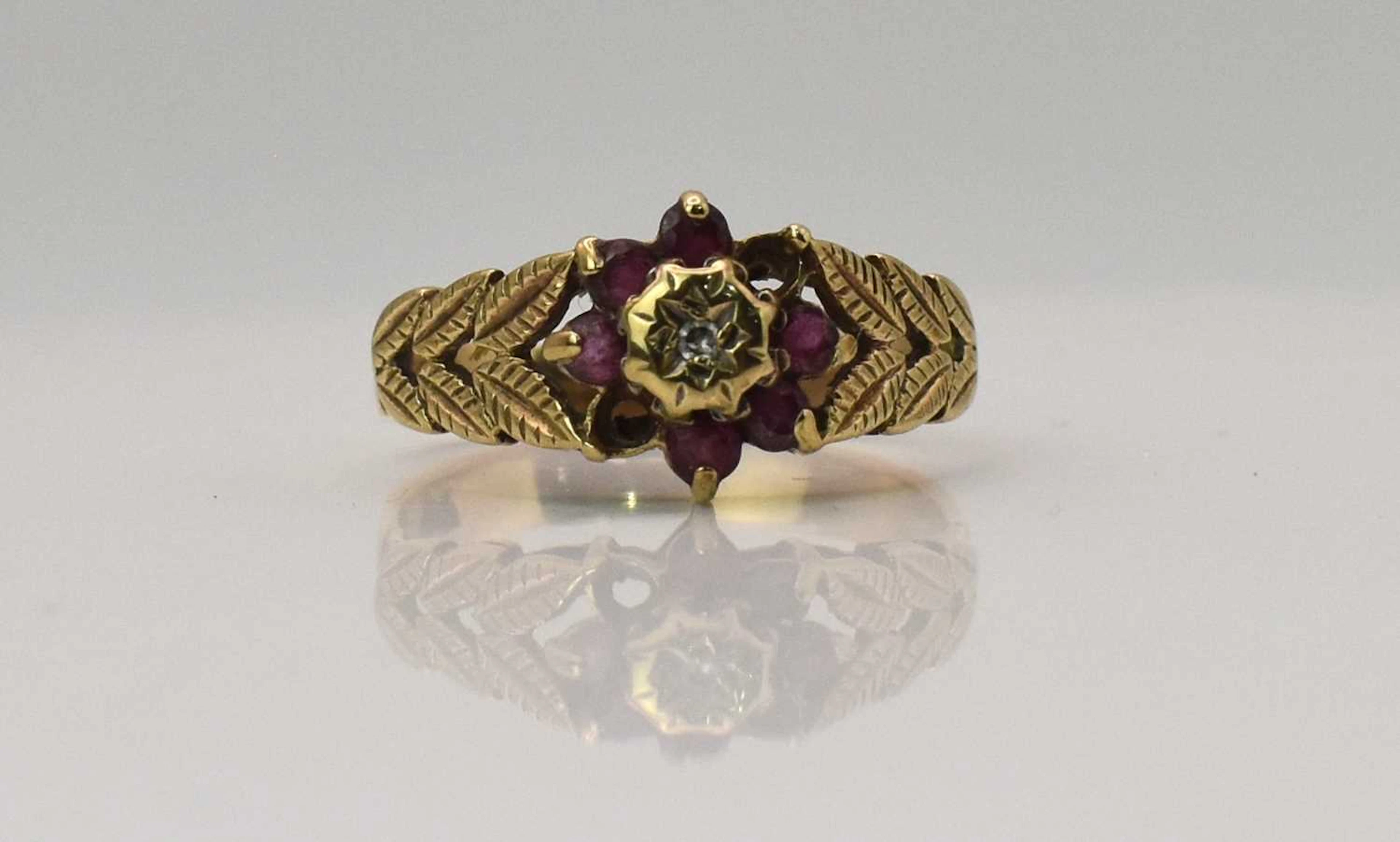 A yellw metal diamon and garnet set flower head cluster...
