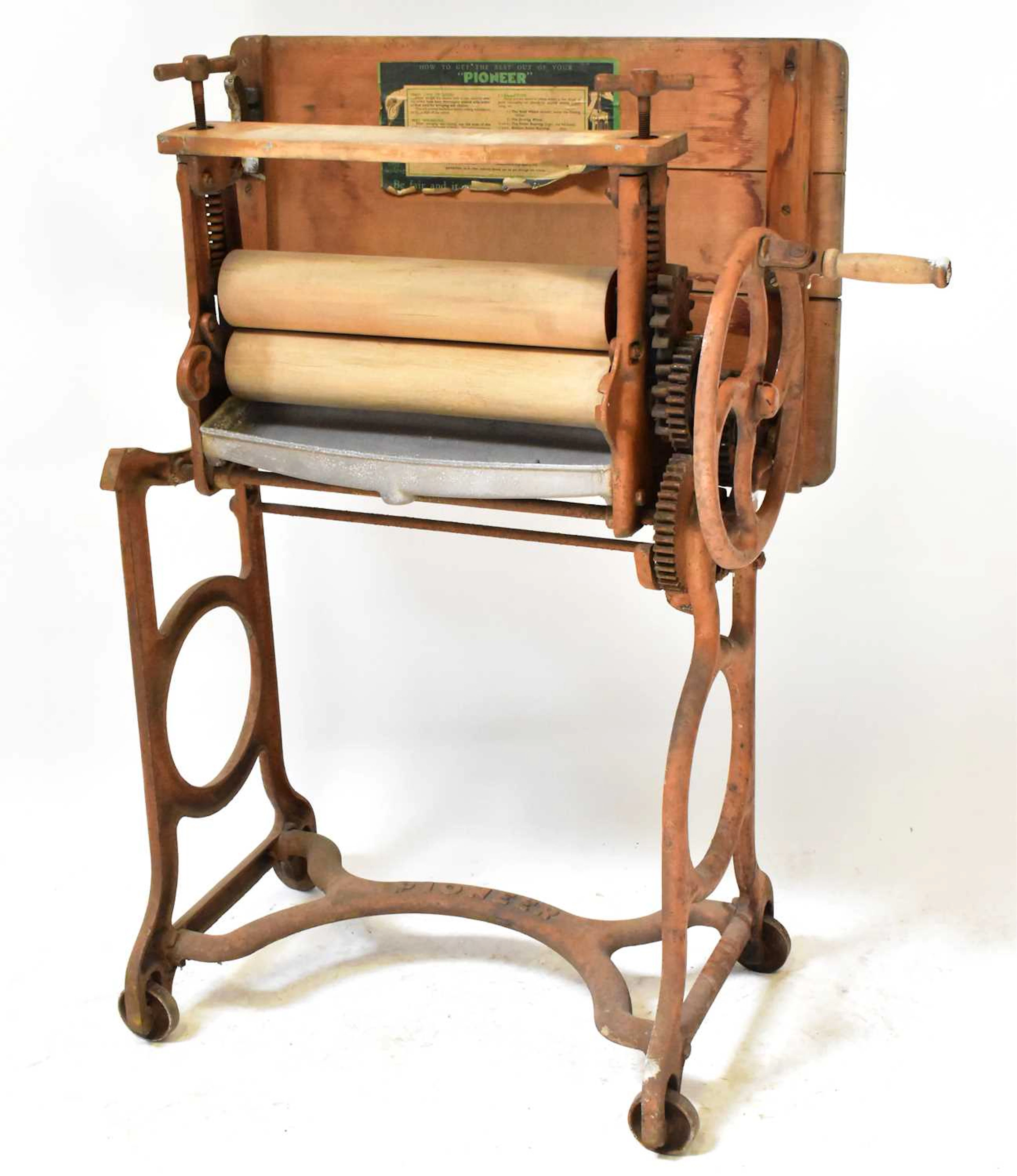 A vintage Pioneer cast iron mangle with wooden rollers and folding table top