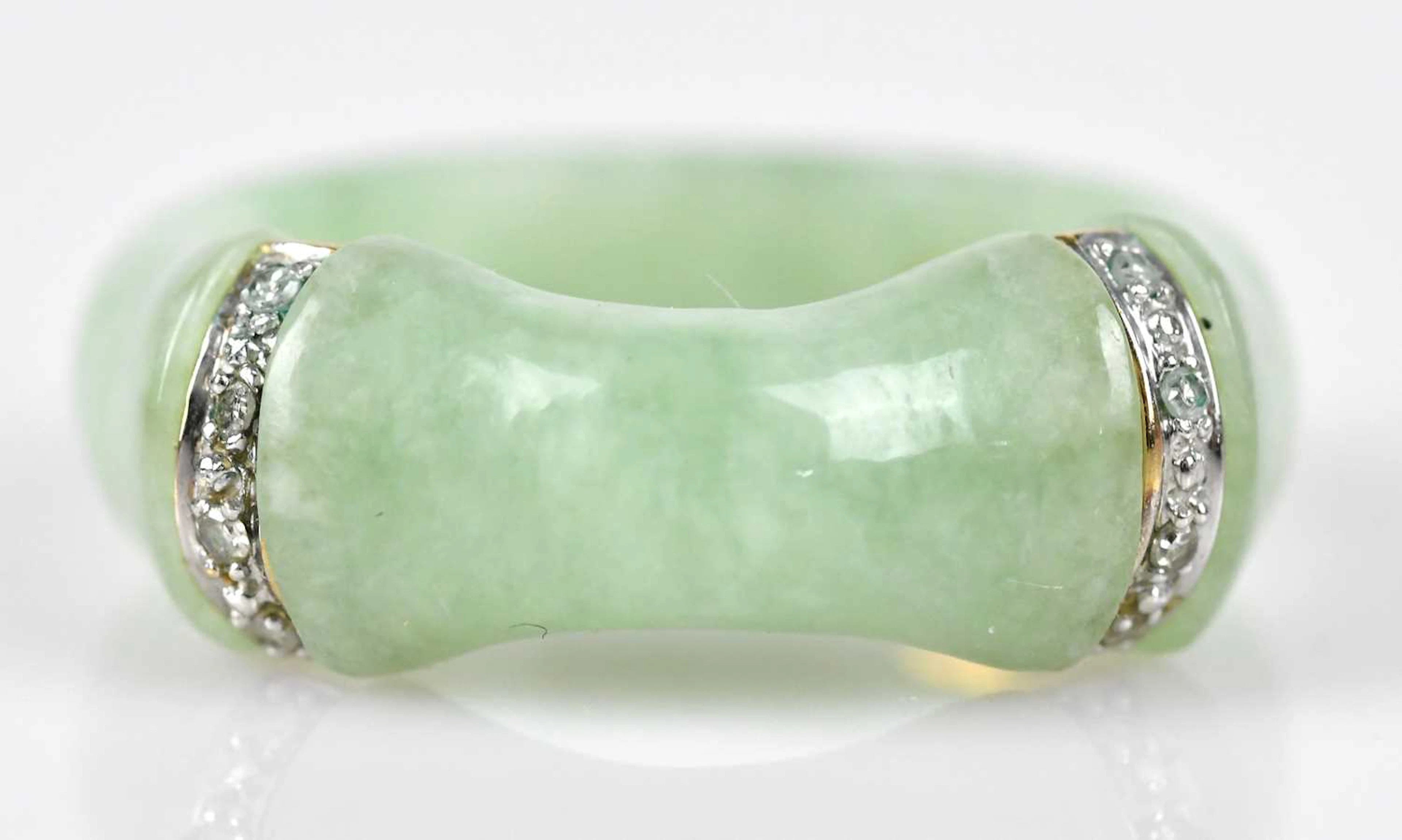 A Chinese green hardstone dress ring set with two yellow and white metal bands