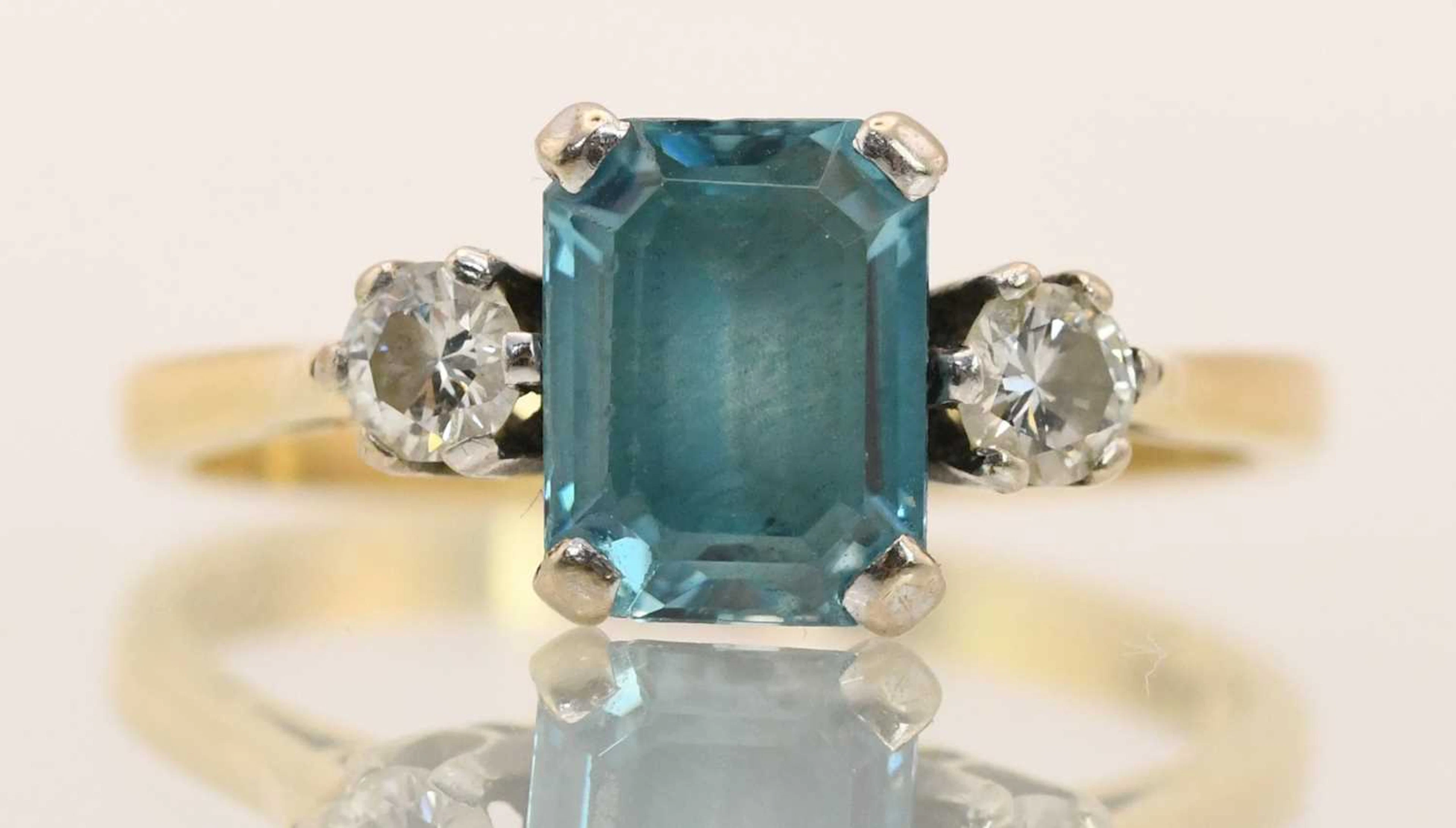 An 18ct yellow gold blue zircon and diamond set three stone ring