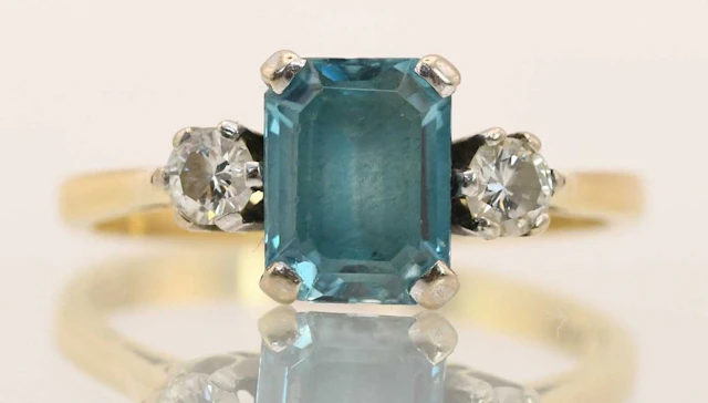 An 18ct yellow gold blue zircon and diamond set three stone ring