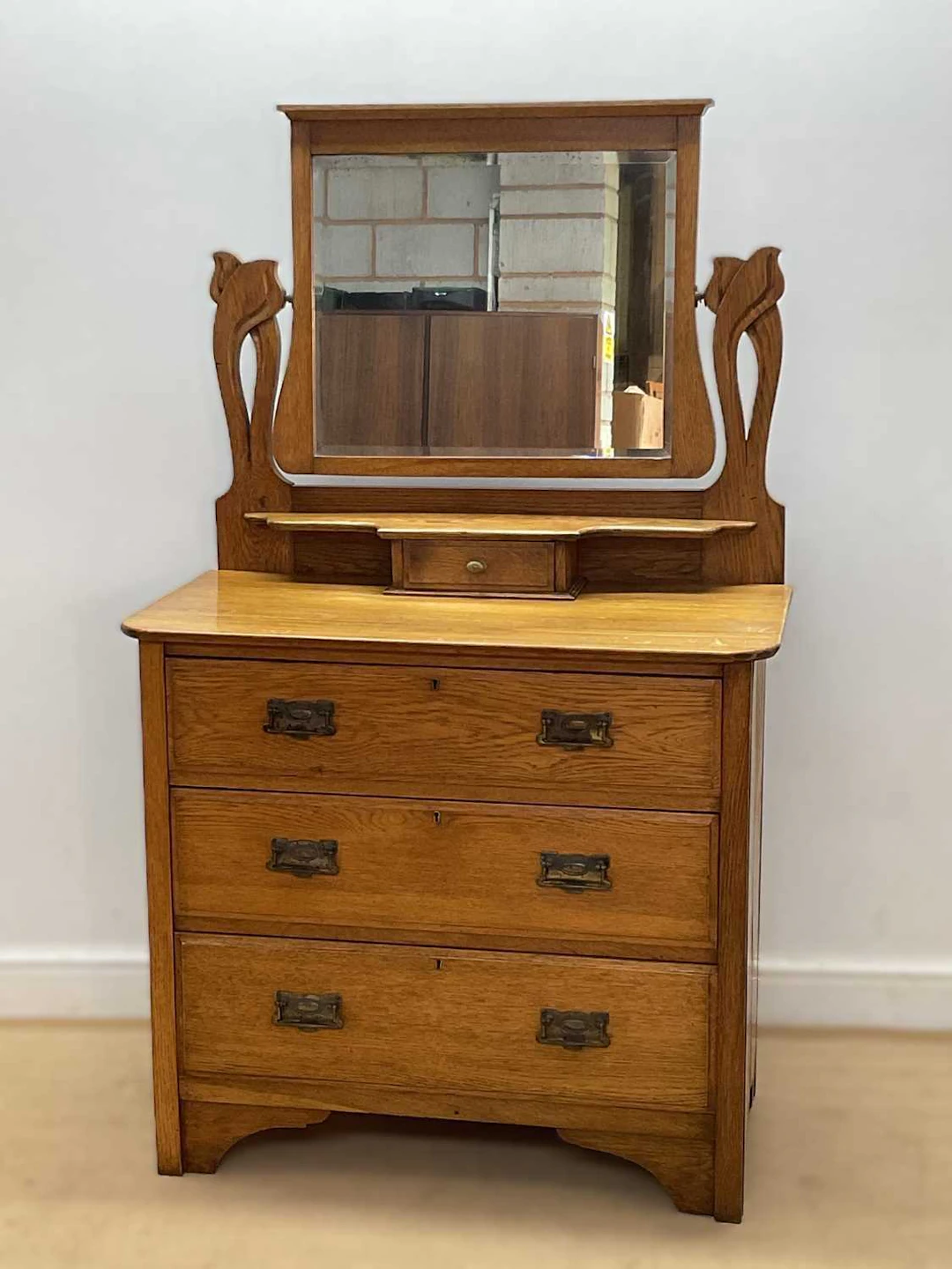 An Art Noveau oak three drawer dressing chest